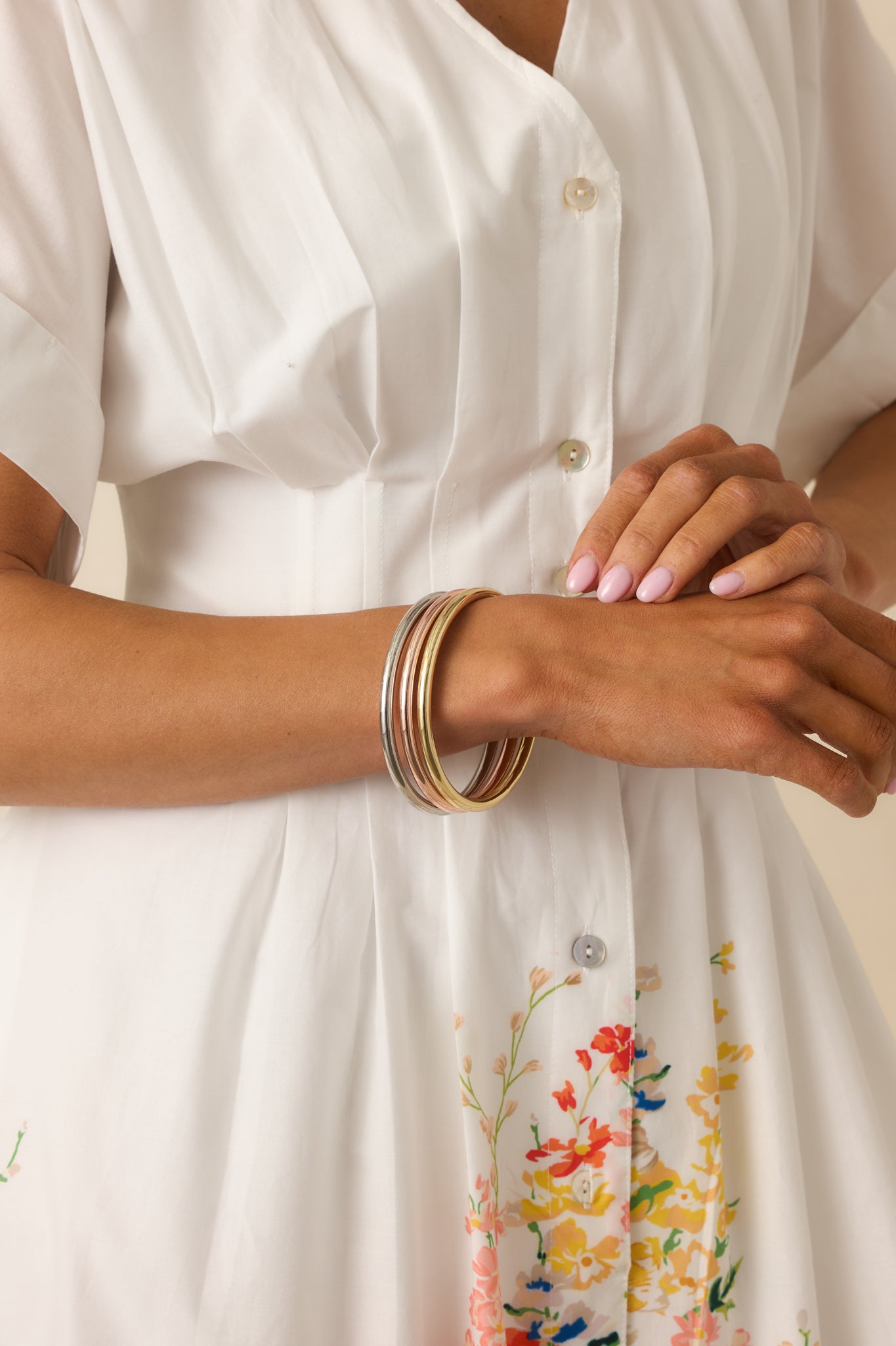 Close cropped angle highlighting the stacked bangle design and reflective metal surface.