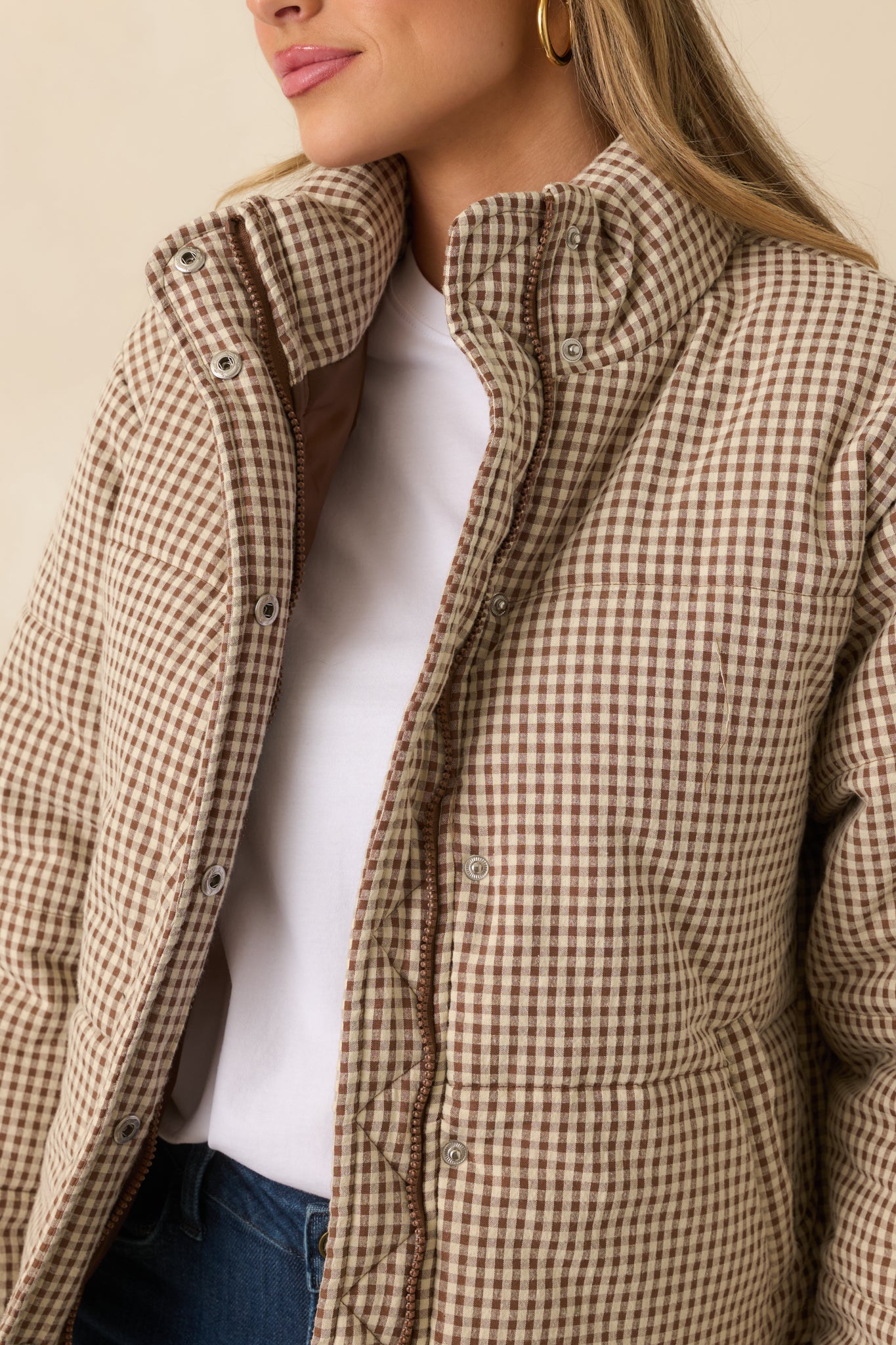 Close detail of the brown gingham quilted fabric showing light padding and smooth texture.