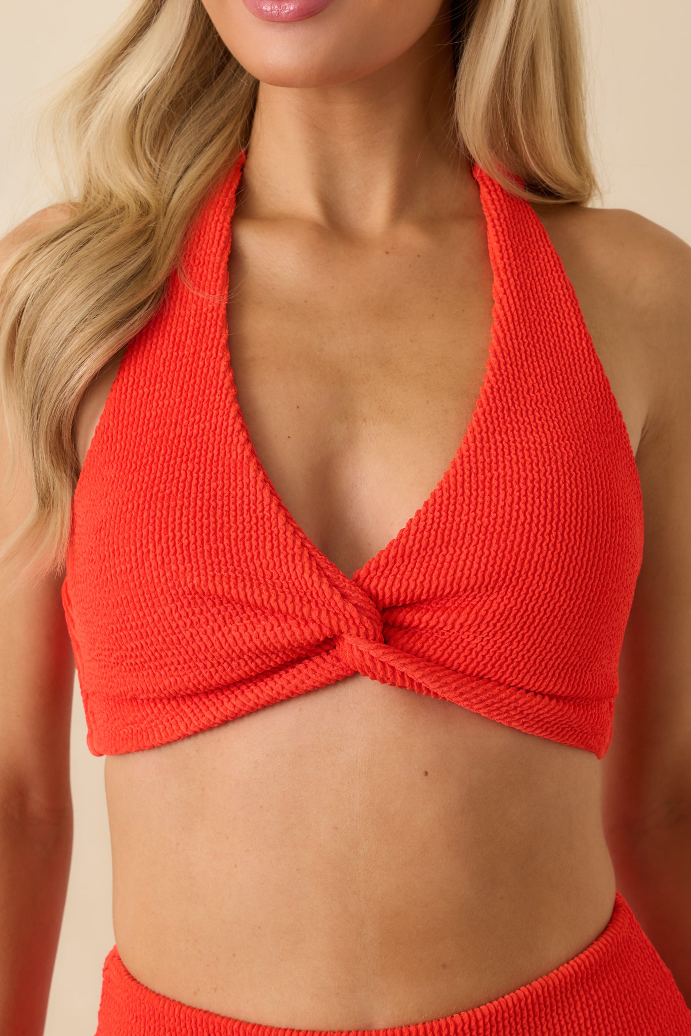 Ultra-close detail of the textured red fabric and centered twist.