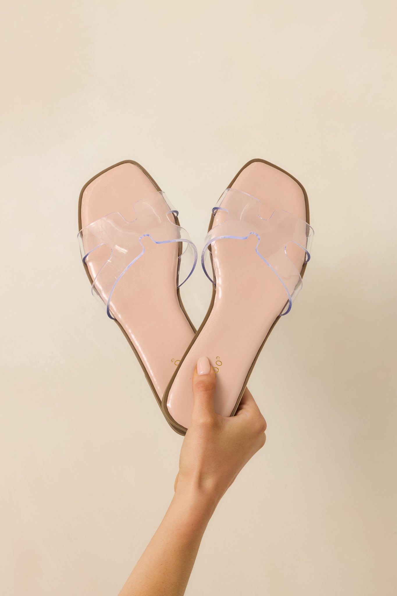 Close-in crop showing smooth nude footbed and transparent strap detail.