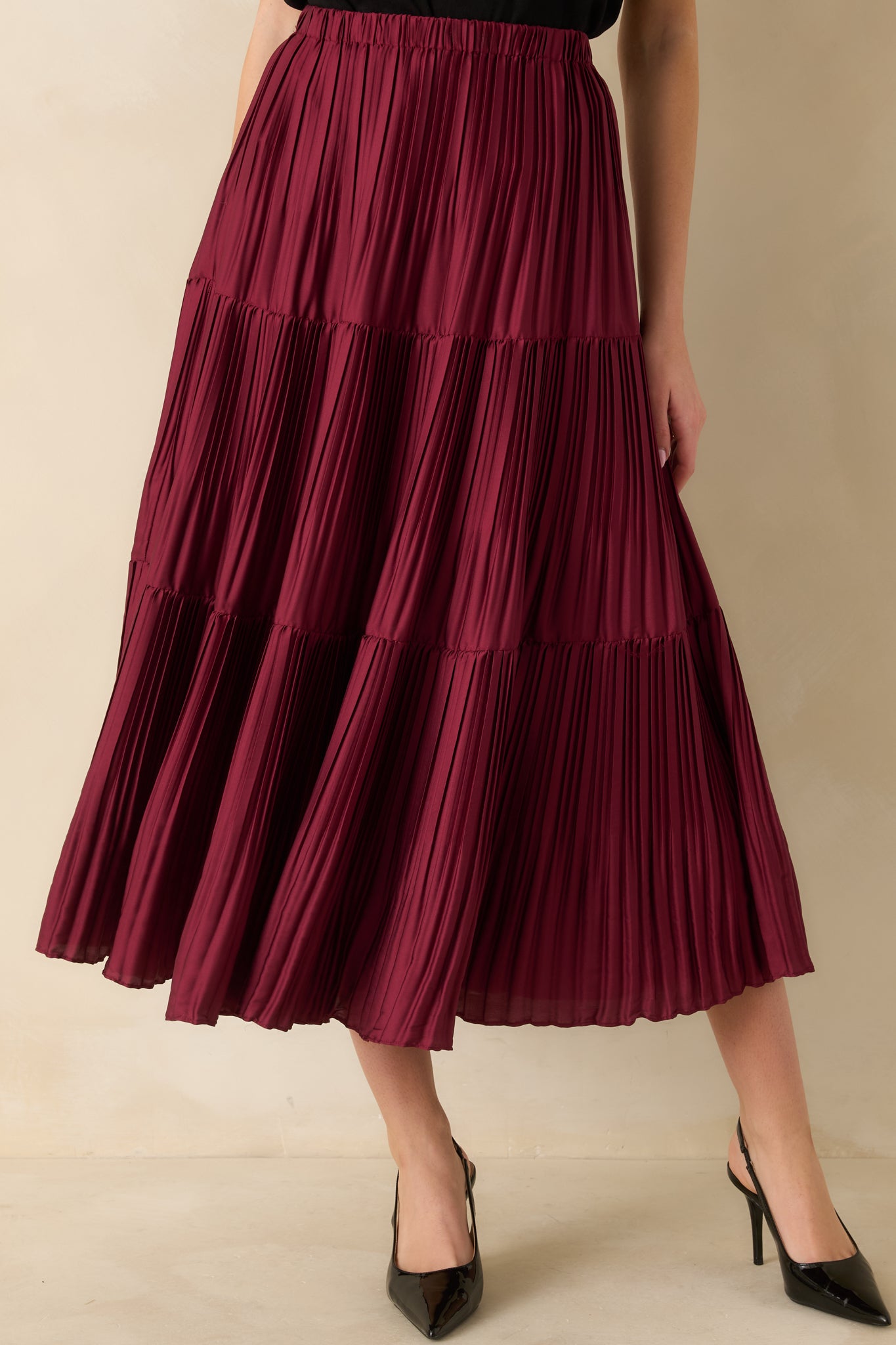 Close-up crop showing the layered pleats and drape of the burgundy woven fabric.