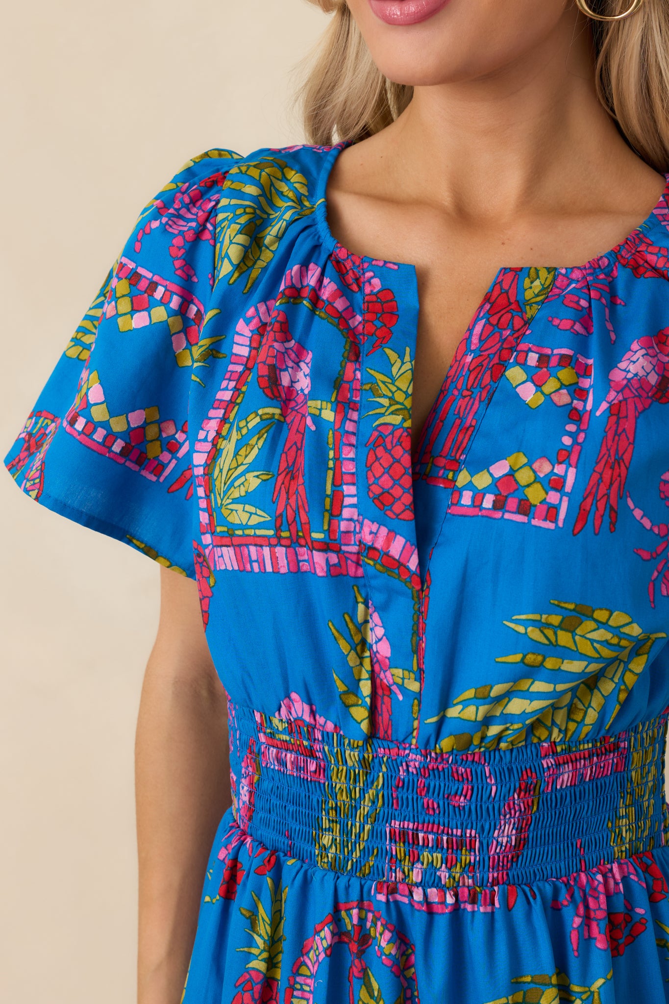 Close-up of the blue tropical mosaic print and smocked waistband with tiered skirt detailing.