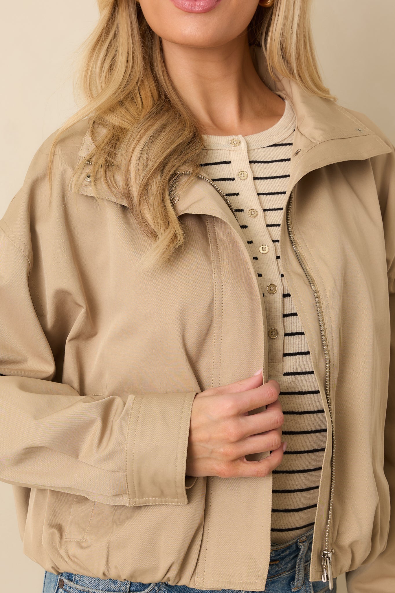 Close-up of the khaki woven fabric showing texture, snap collar detail, and smooth lining.