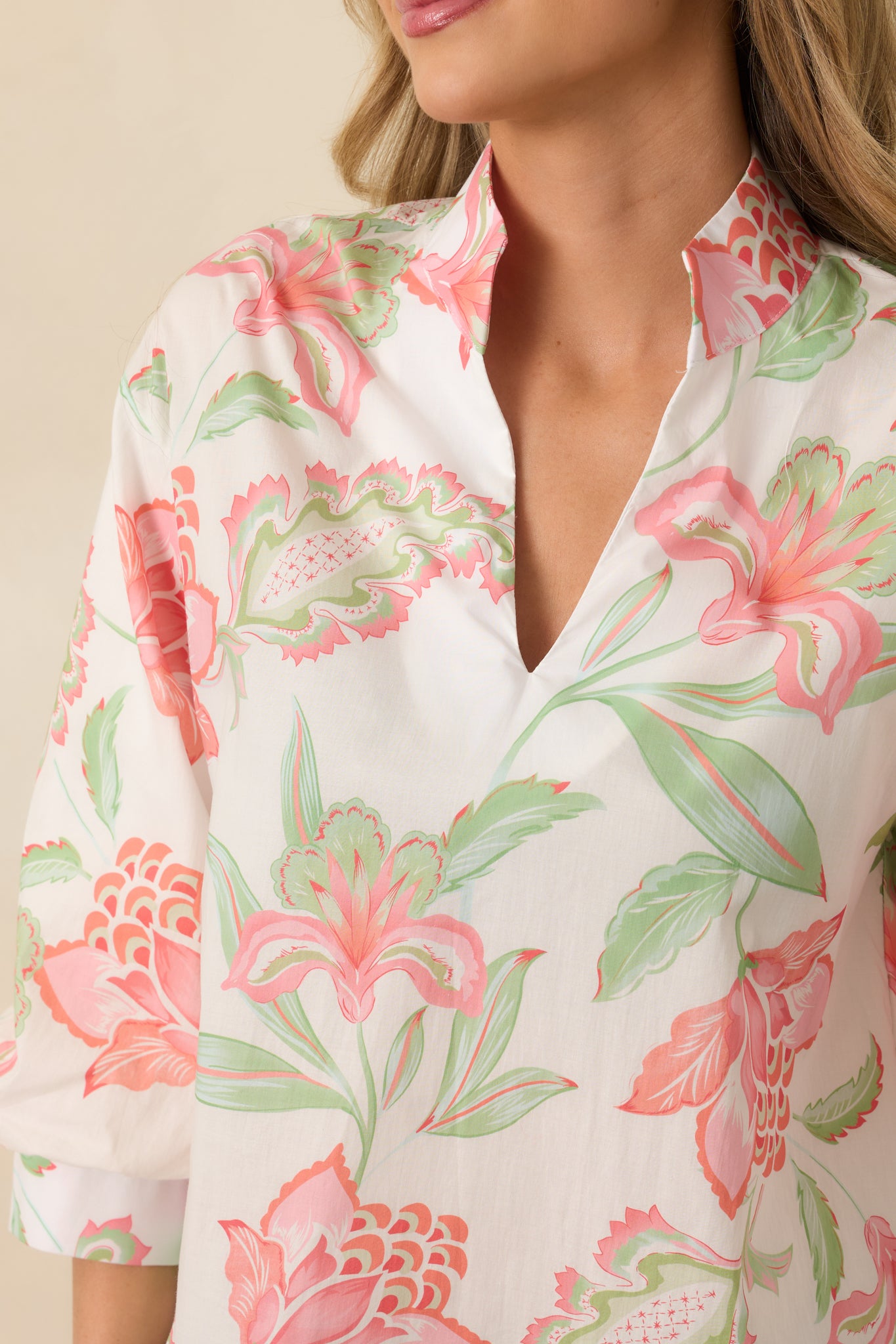 Close-up of the peach top highlighting the multicolor pattern, scalloped hem, and fabric texture.