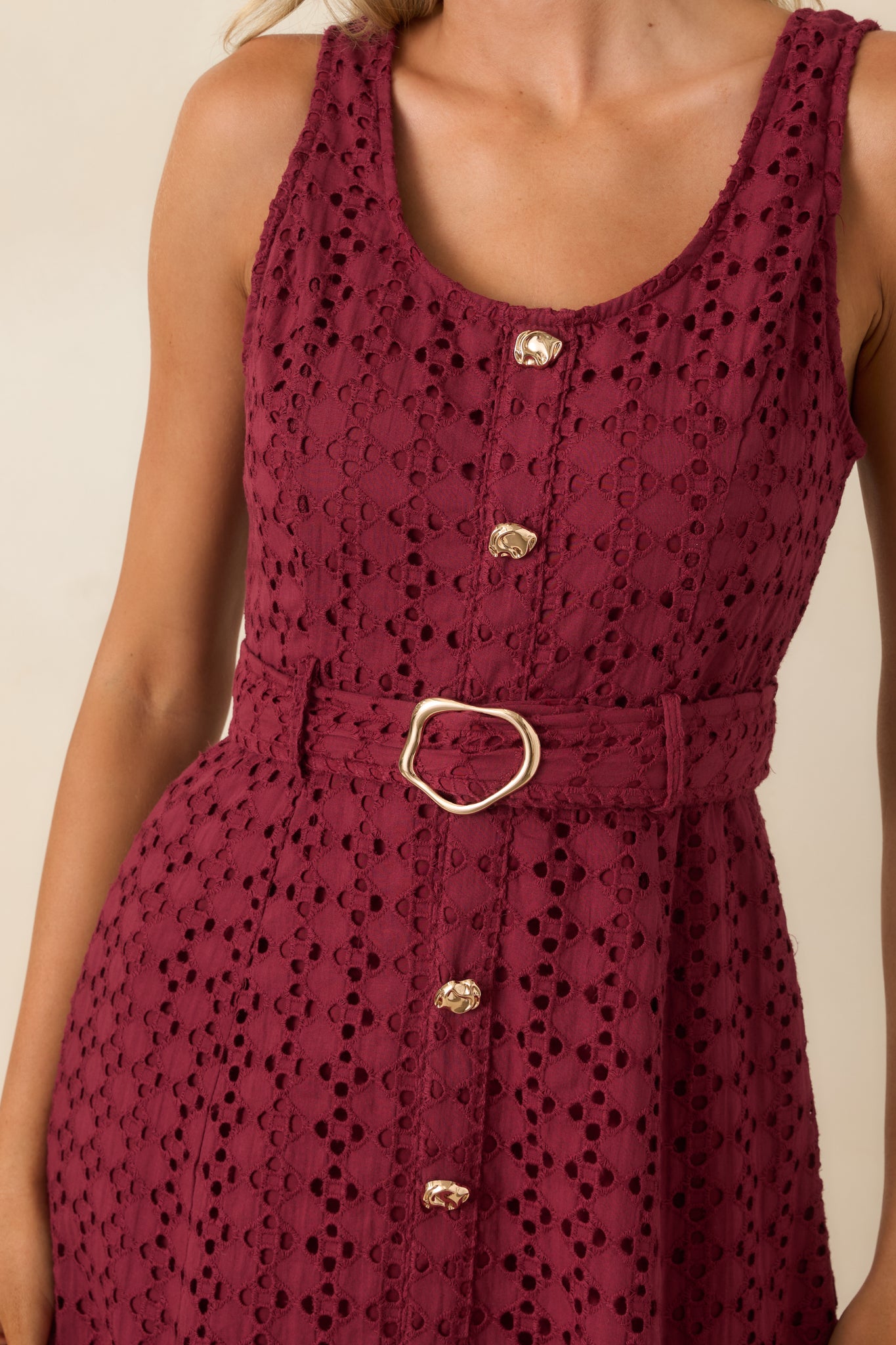 Close-up of the burgundy cotton dress highlighting the intricate eyelet embroidery, faux button front detail, and textured fabric.