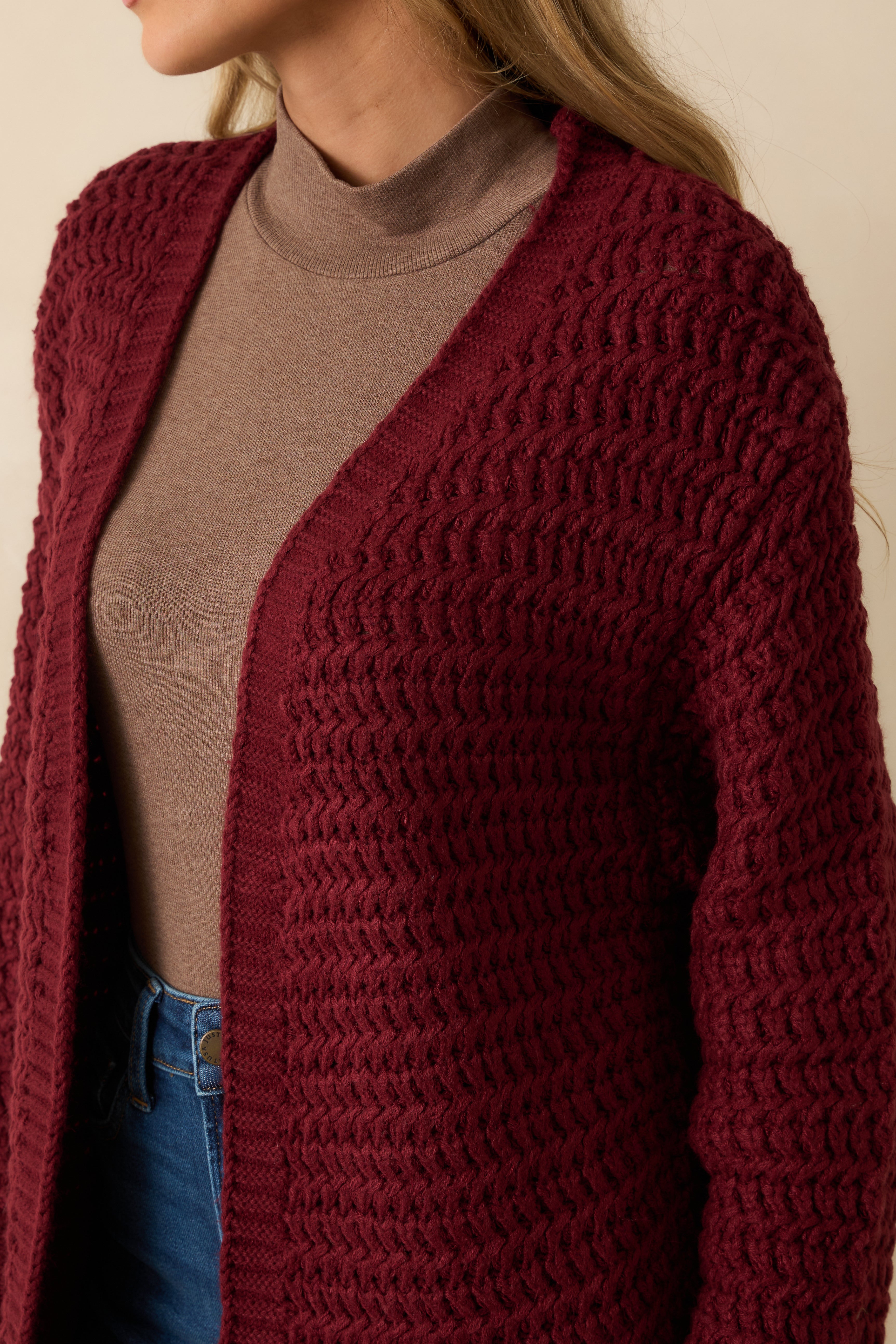 Close-up of the chunky knit pattern and ribbed trim detailing.