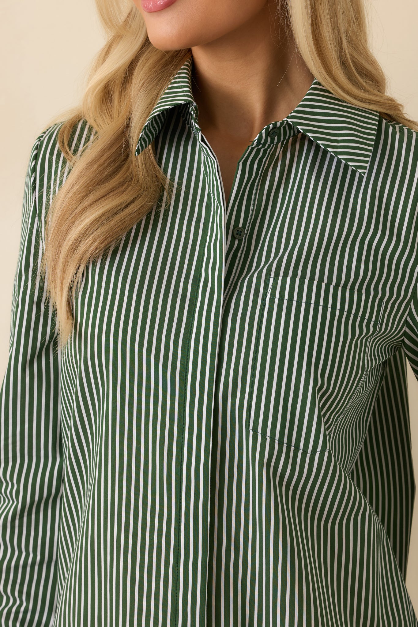 Close-up of the concealed button placket blending seamlessly into the dark olive striped woven fabric.