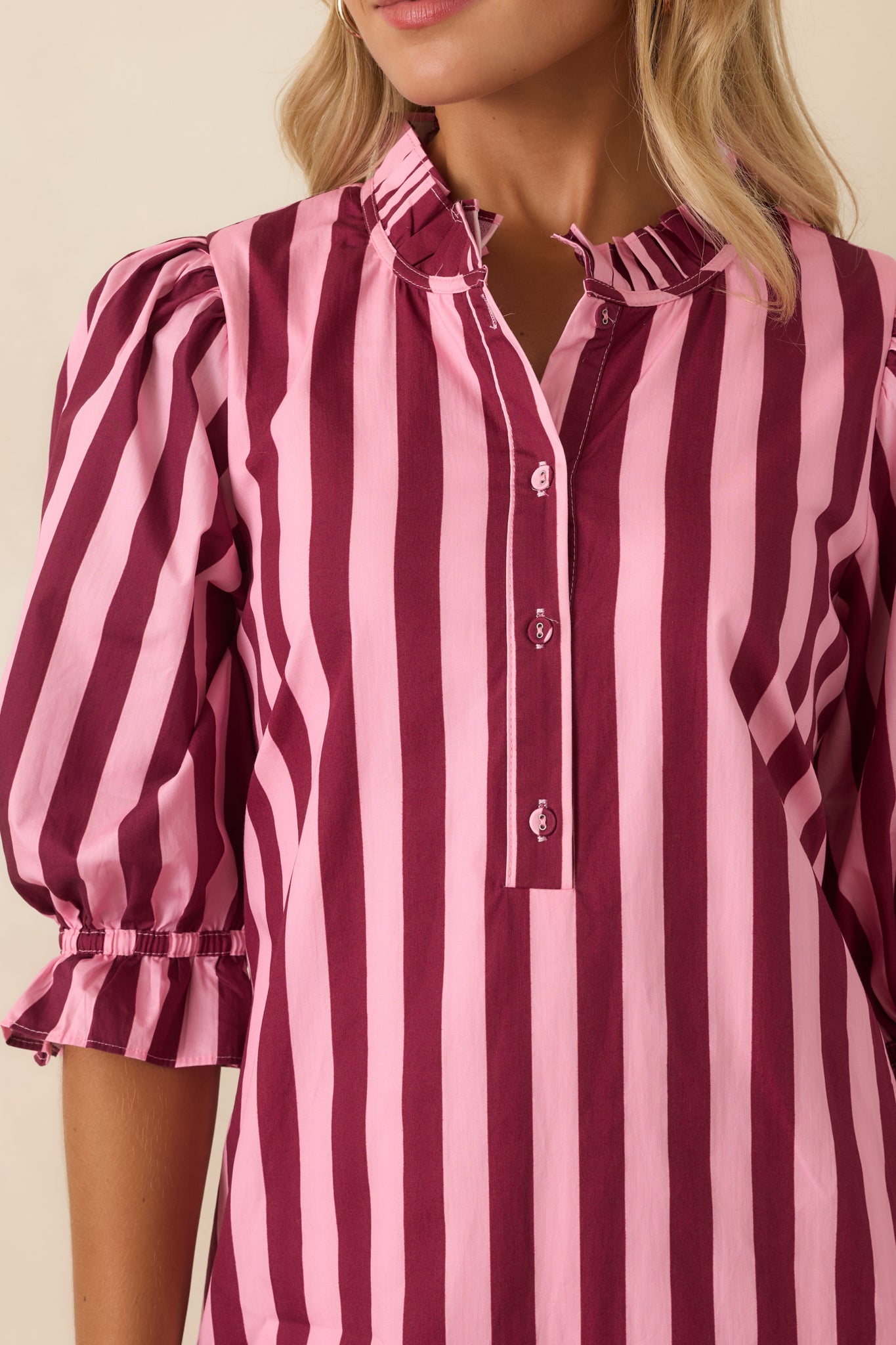 Close-up of the cotton mini dress highlighting the ruffled mock collar, button-front placket, striped fabric, and cuff details.