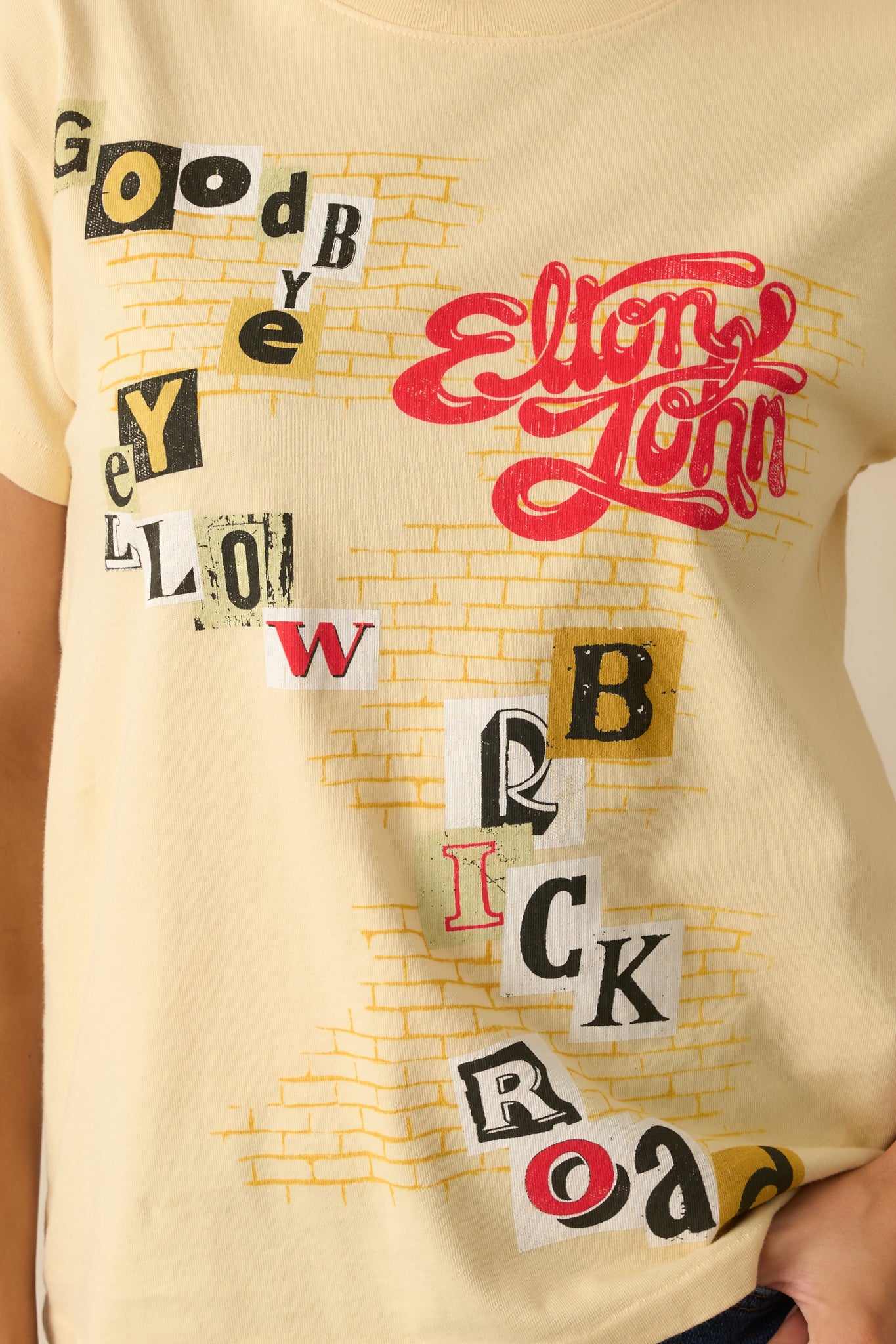 Close-up detail of the graphic showing the brick road illustration and collaged letters.