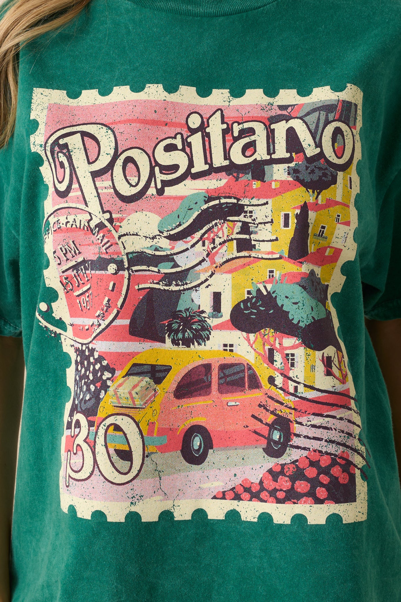 A close-up detail of the Positano postage stamp graphic against the acid wash green fabric.
