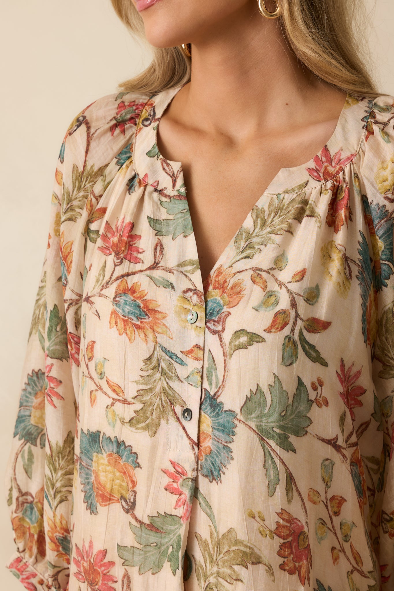 Close-up of the floral print and button-cuffed sleeve, showing the fine details of the fabric.