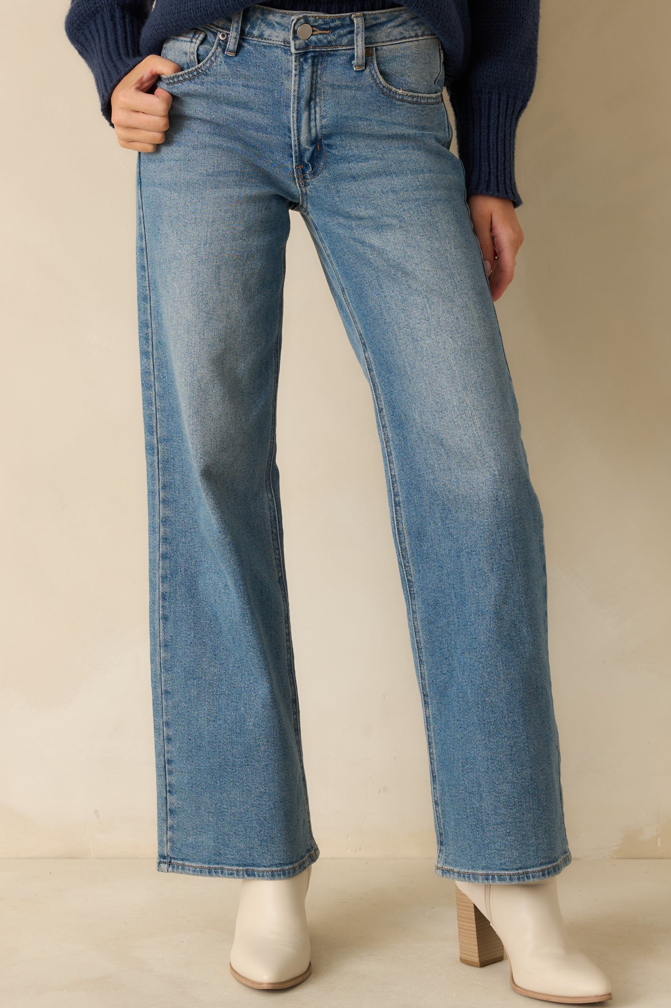 Close-in front view highlighting the button closure, zipper, and smooth denim texture.