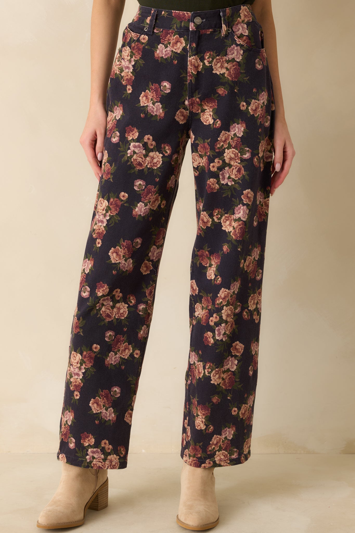 Close-up of the front waist and upper thigh of navy floral jeans highlighting the high-rise waistband and pocket details.