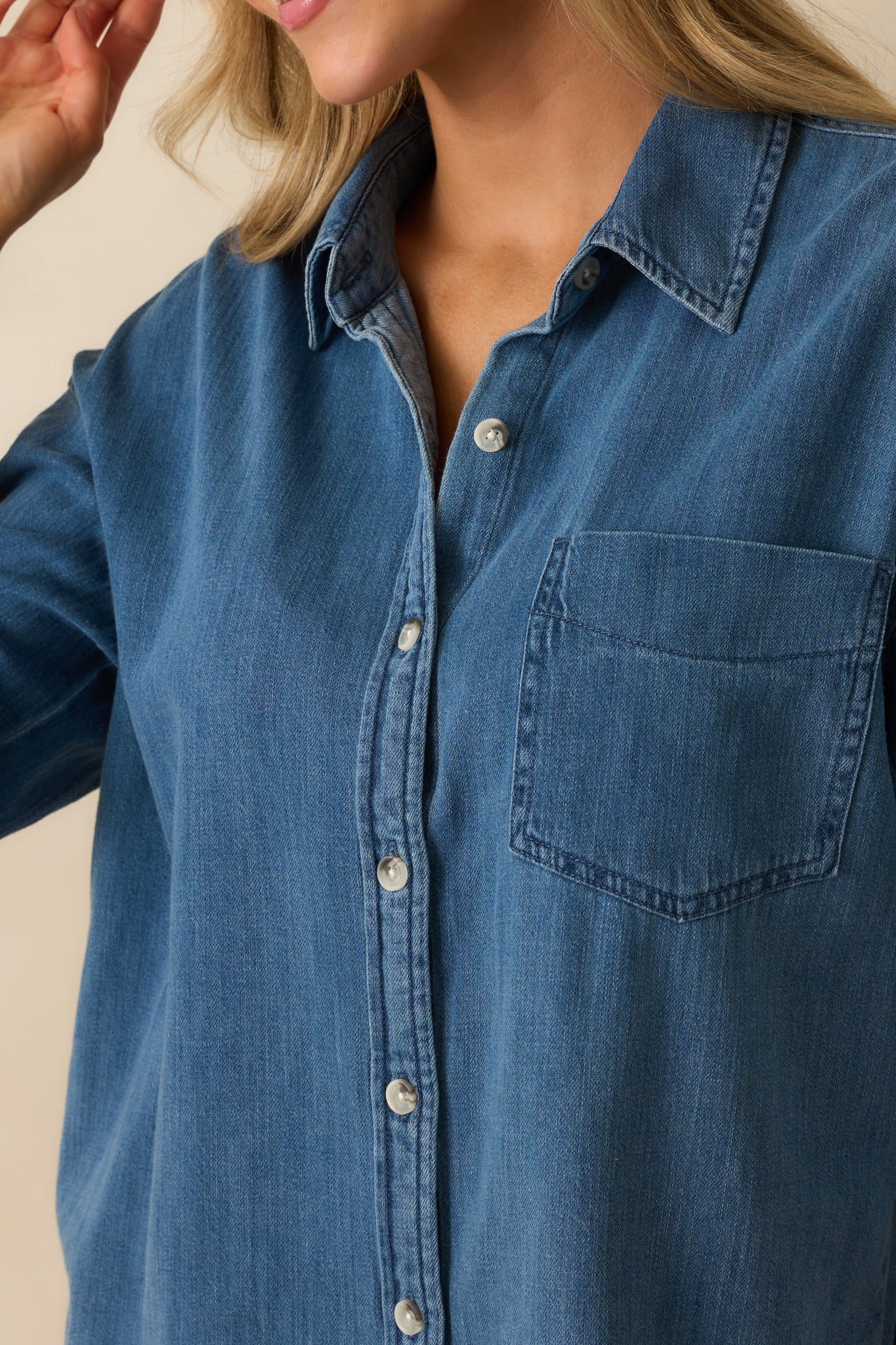 Close-up of the functional buttons, breast pocket, and medium wash fabric texture.