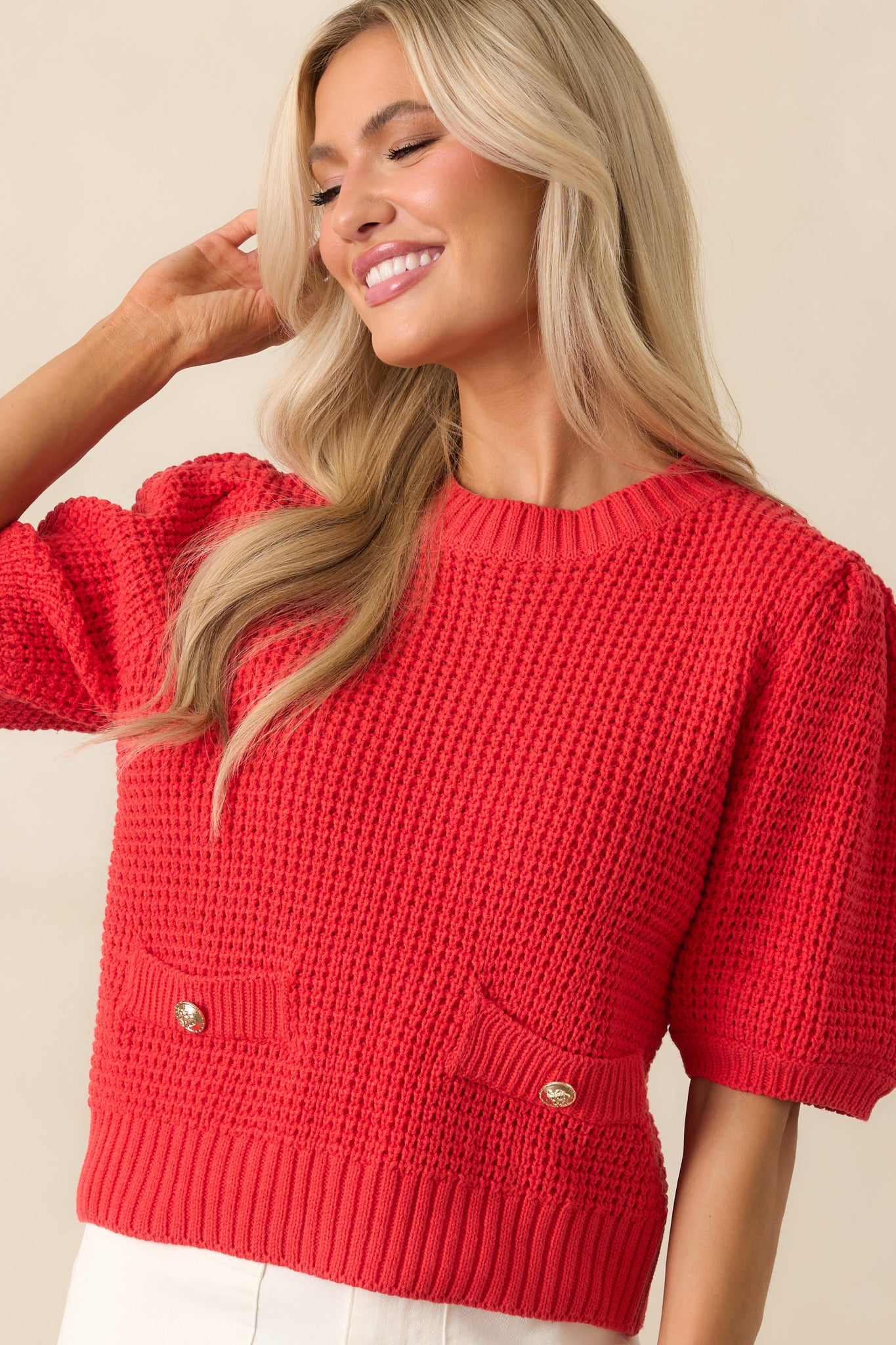 Midsection close-up highlighting the faux pockets with gold buttons and fine knit pattern.