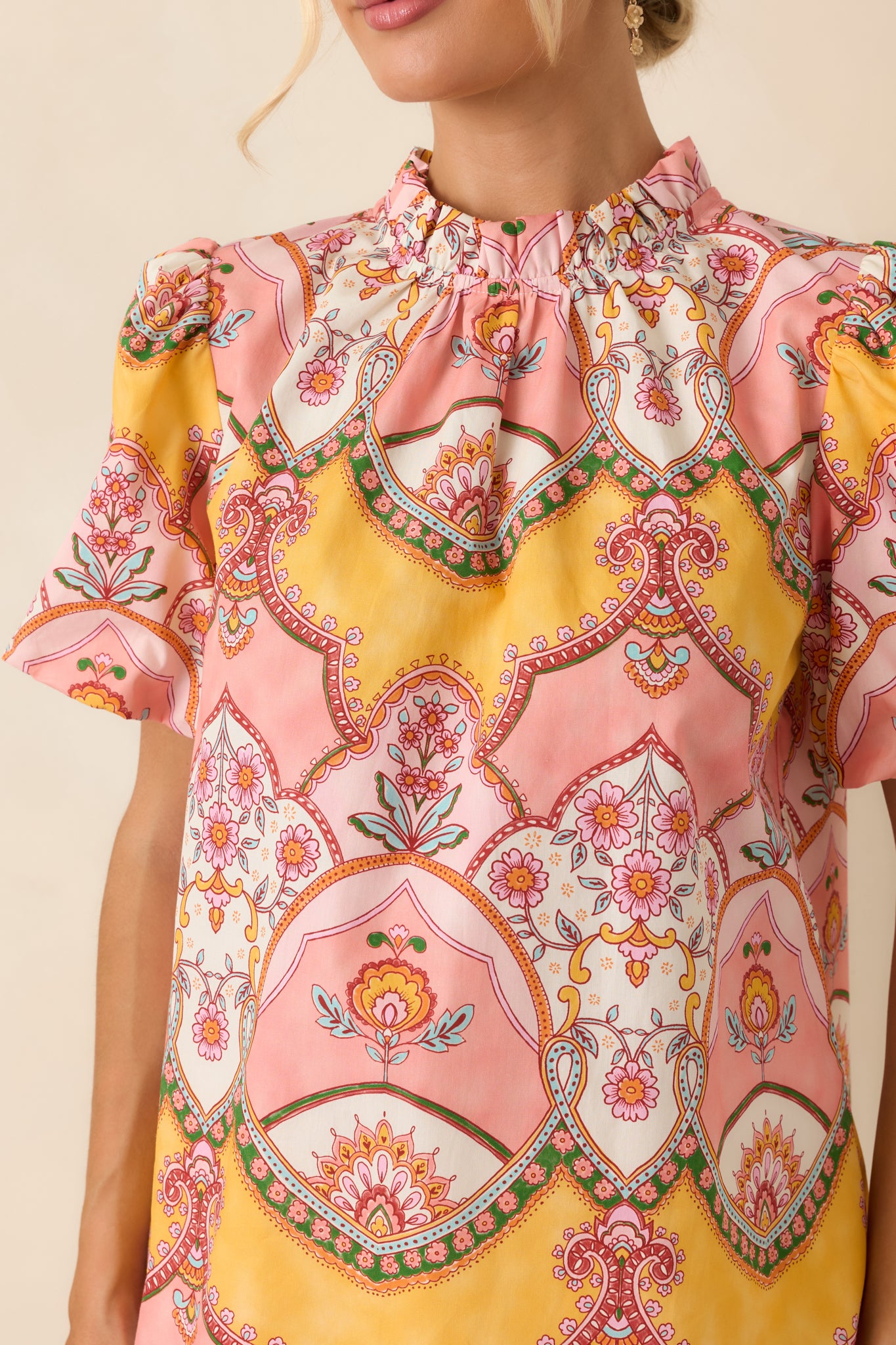 Close-up of the pink and marigold cotton top highlighting the vintage-inspired scarf print, ruffled neckline, and vibrant color palette.