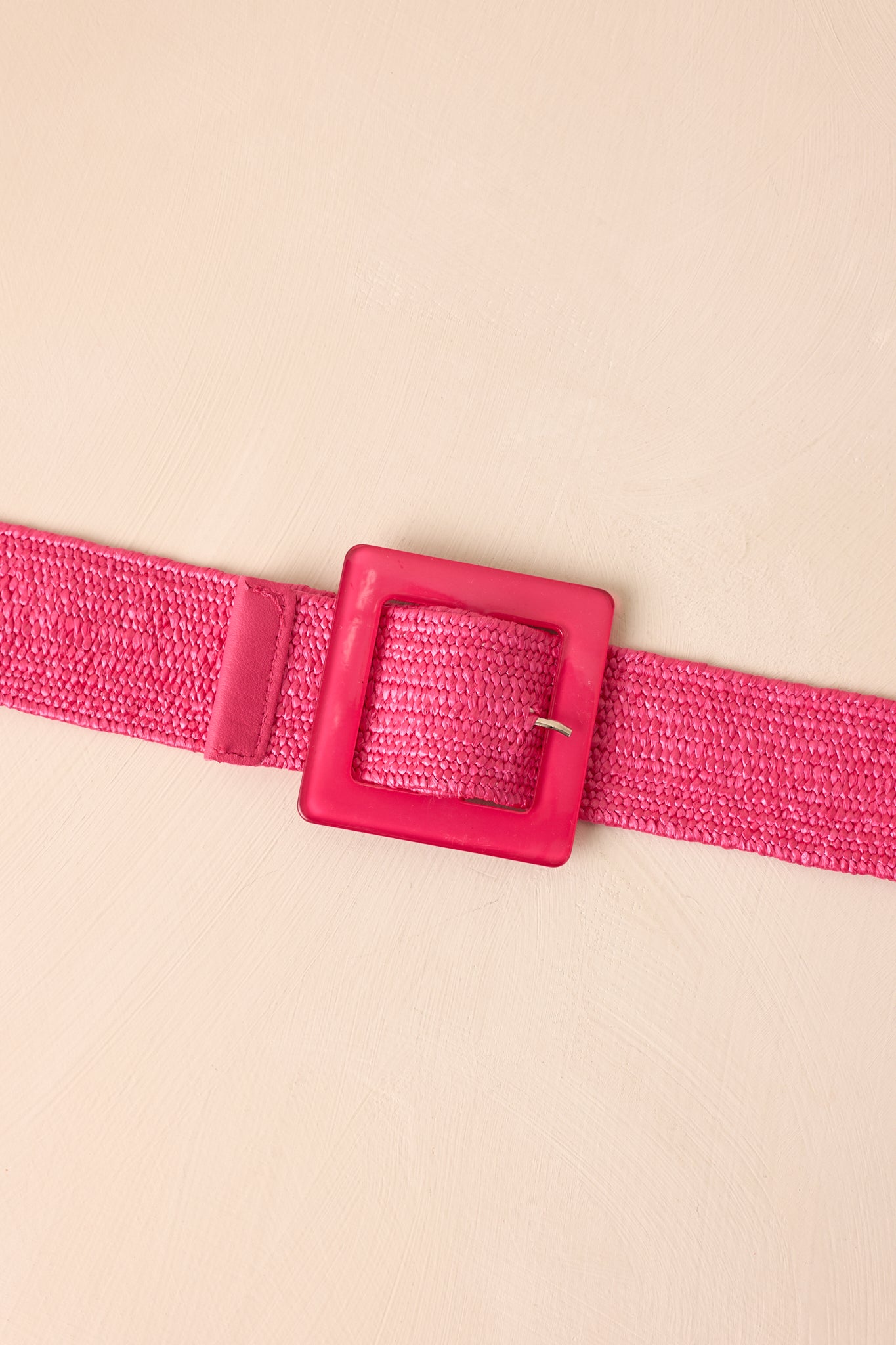 Close-up of hot pink belt featuring woven elastic strap and square acrylic pin buckle