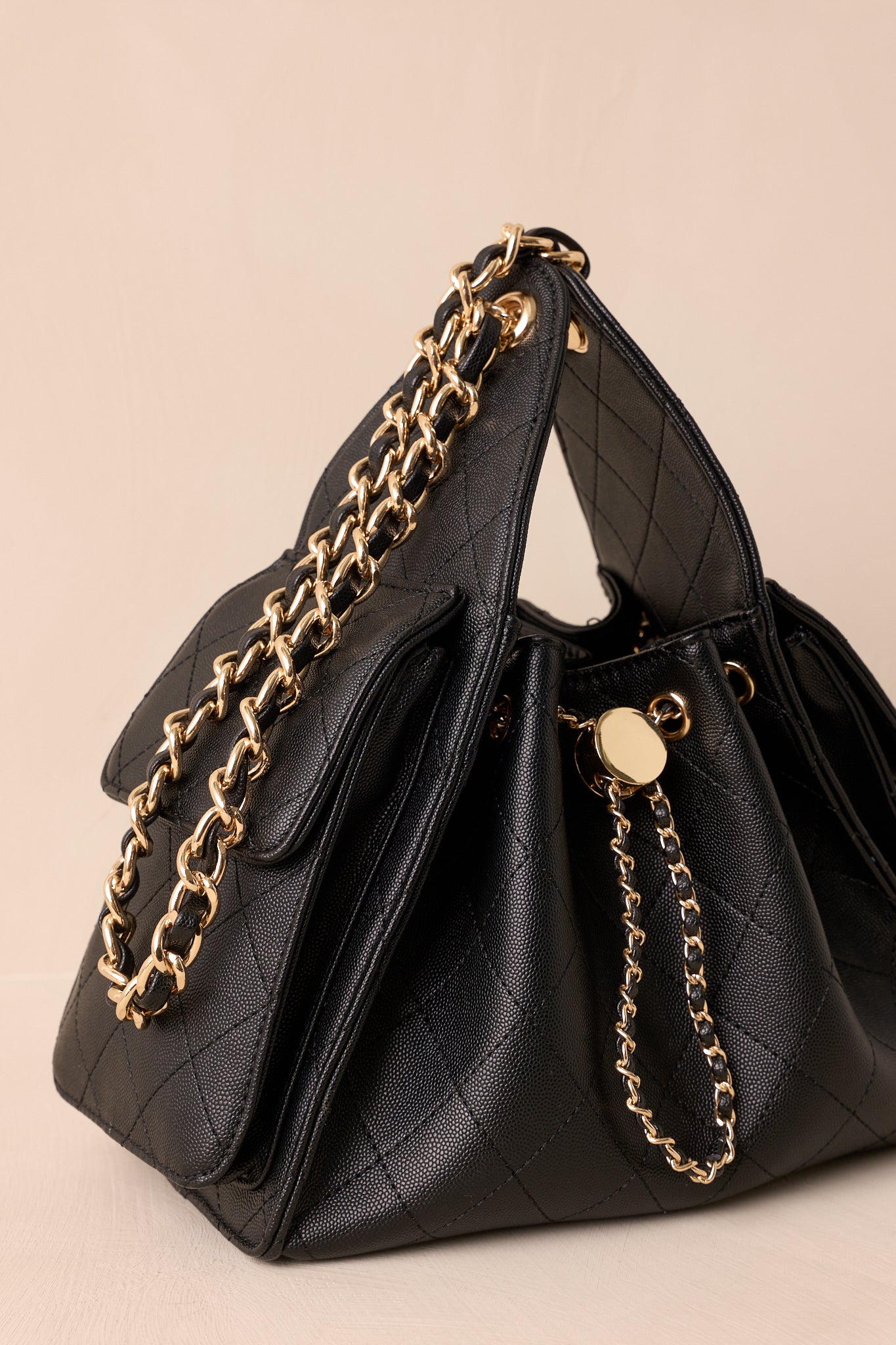 Close-up of the interlaced gold chain and larger faux leather cord strap, highlighting texture and hardware.