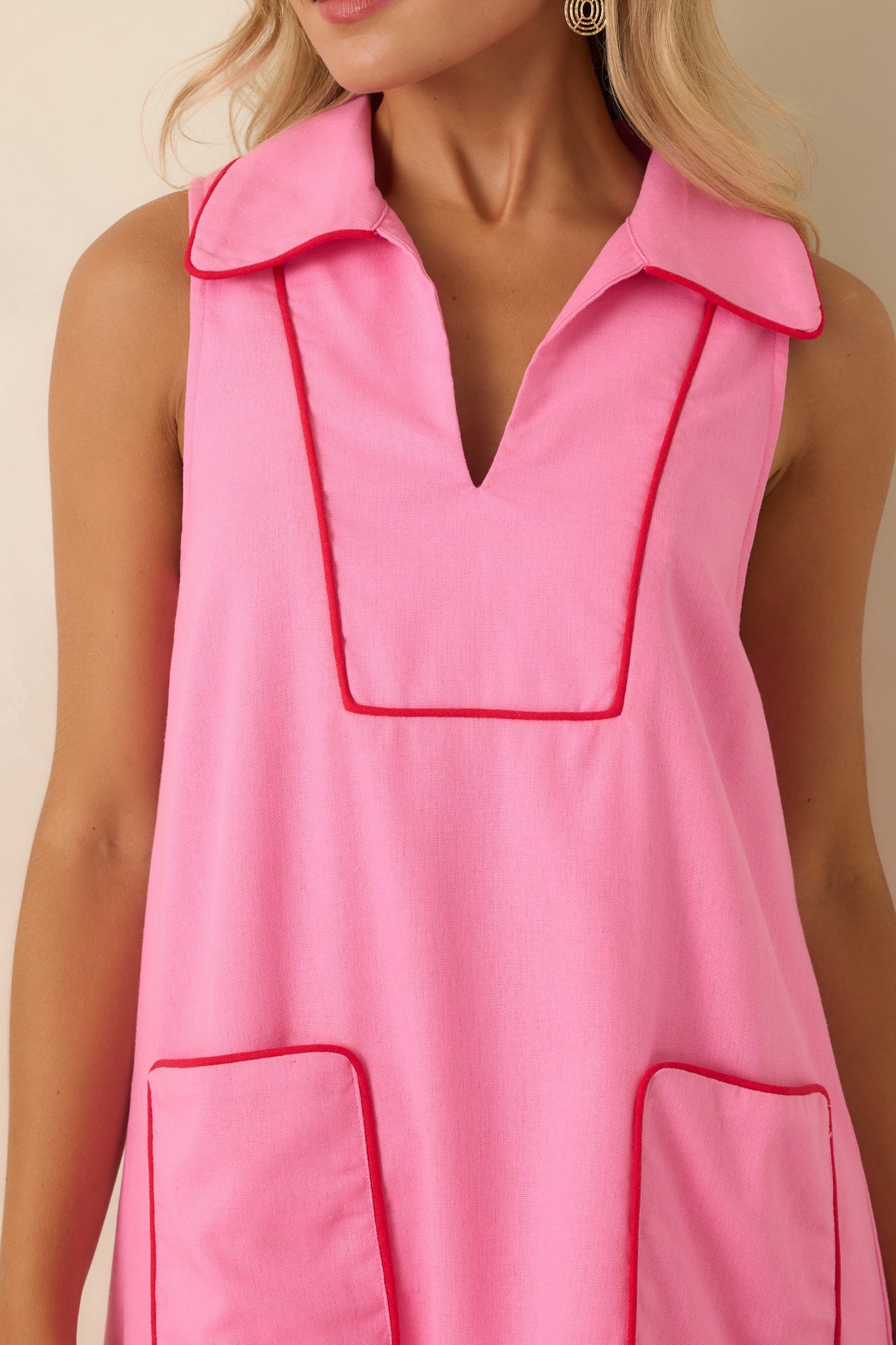 Close-up of the linen blend dress highlighting the split neckline, red piping, collar detail, and textured fabric.