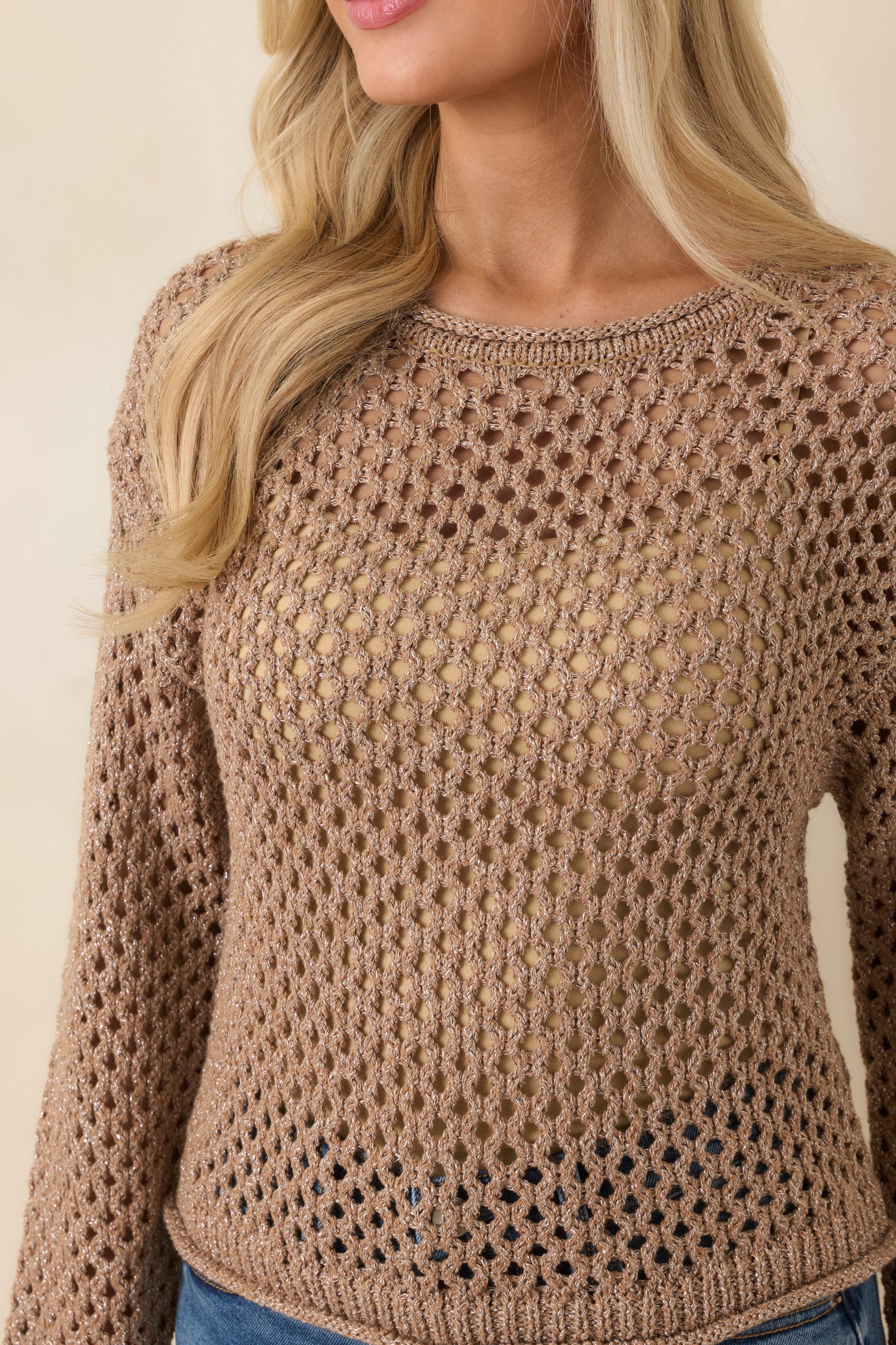 Close-up of mocha brown open-knit crochet fabric revealing subtle shimmer and intricate woven texture.
