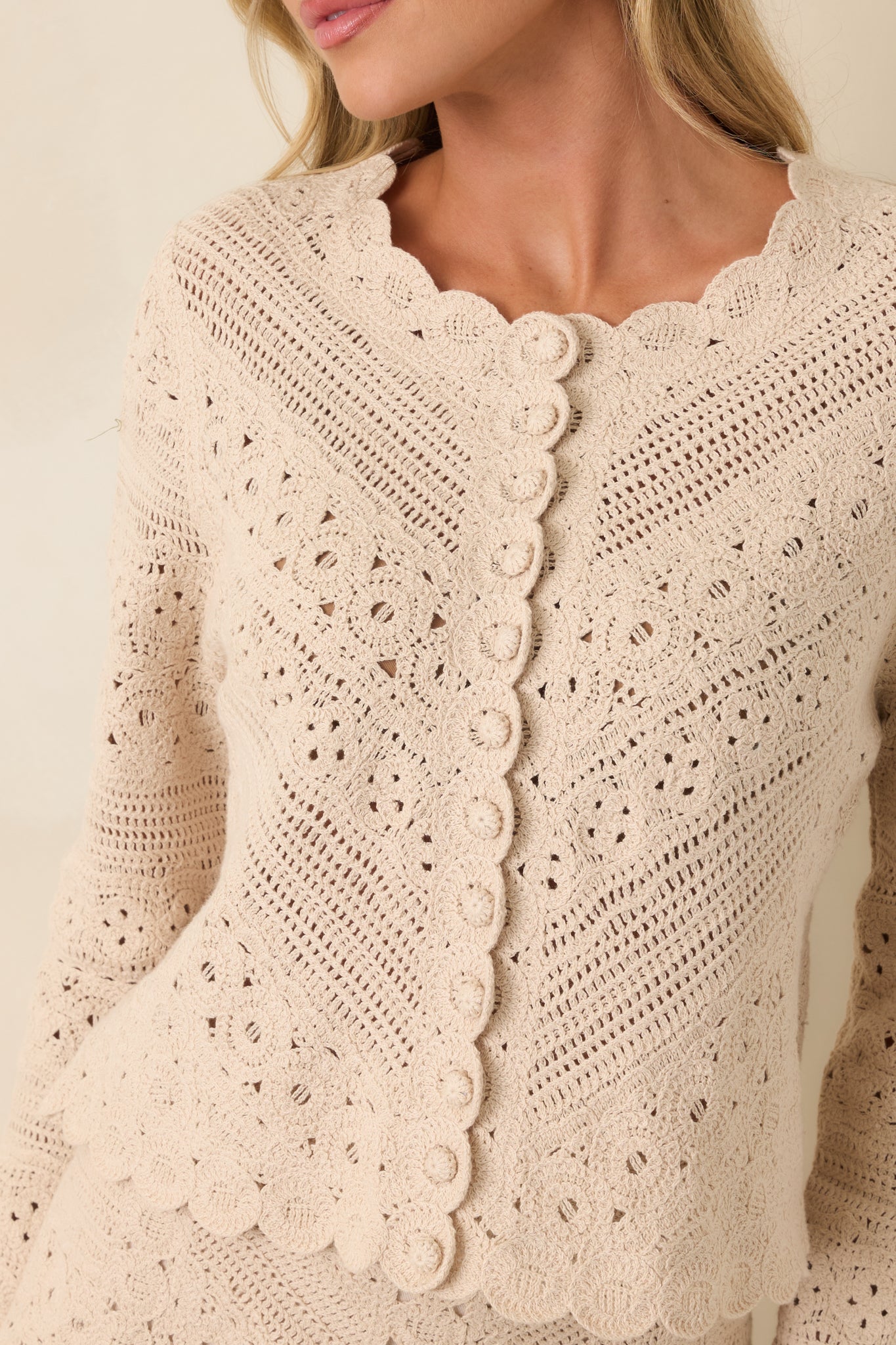Close-up view of the crochet stitching, scalloped edging, and fabric-covered button details.