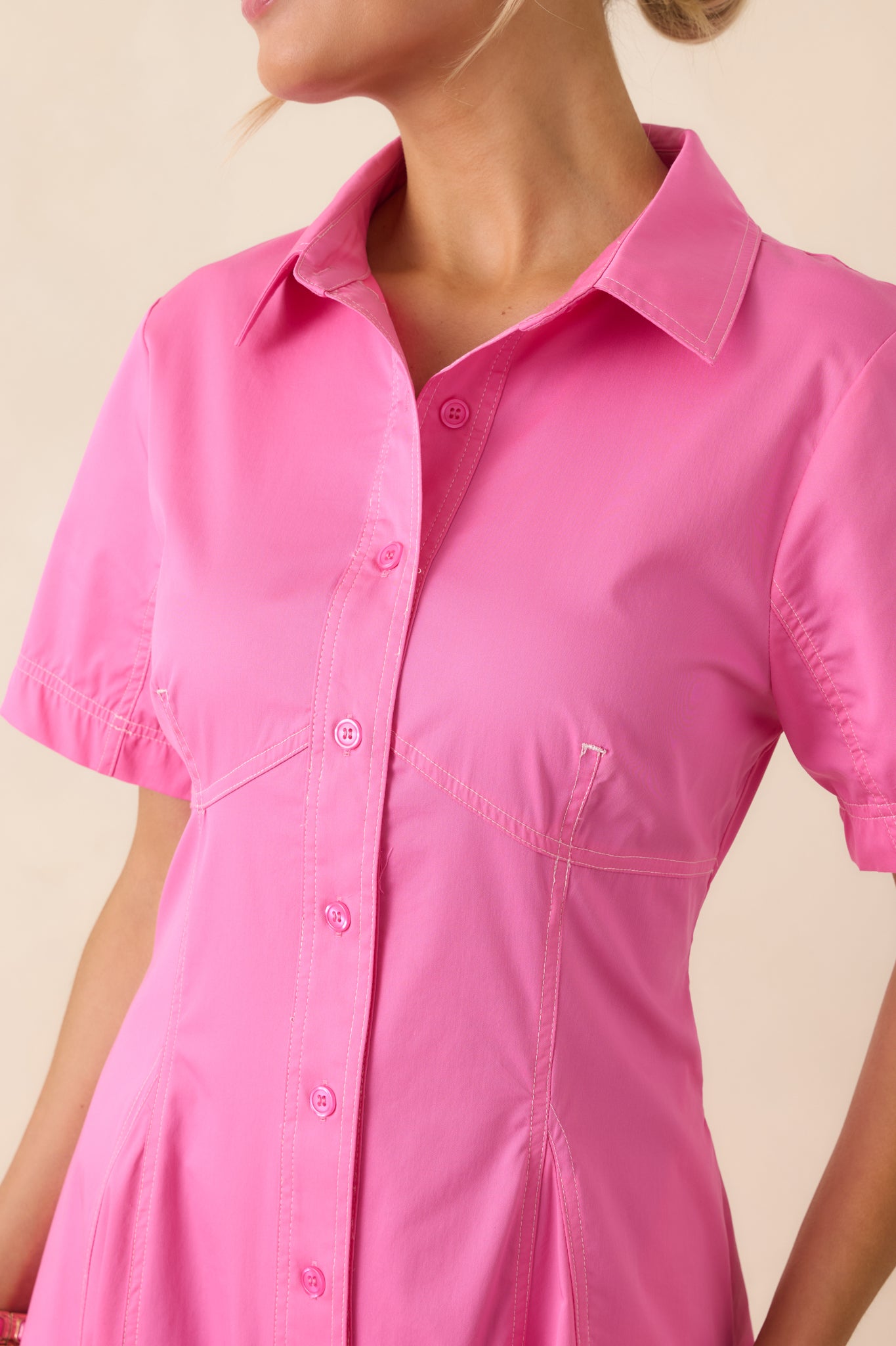 Close-up of full button front and subtle shaping seams on collared midi dress.
