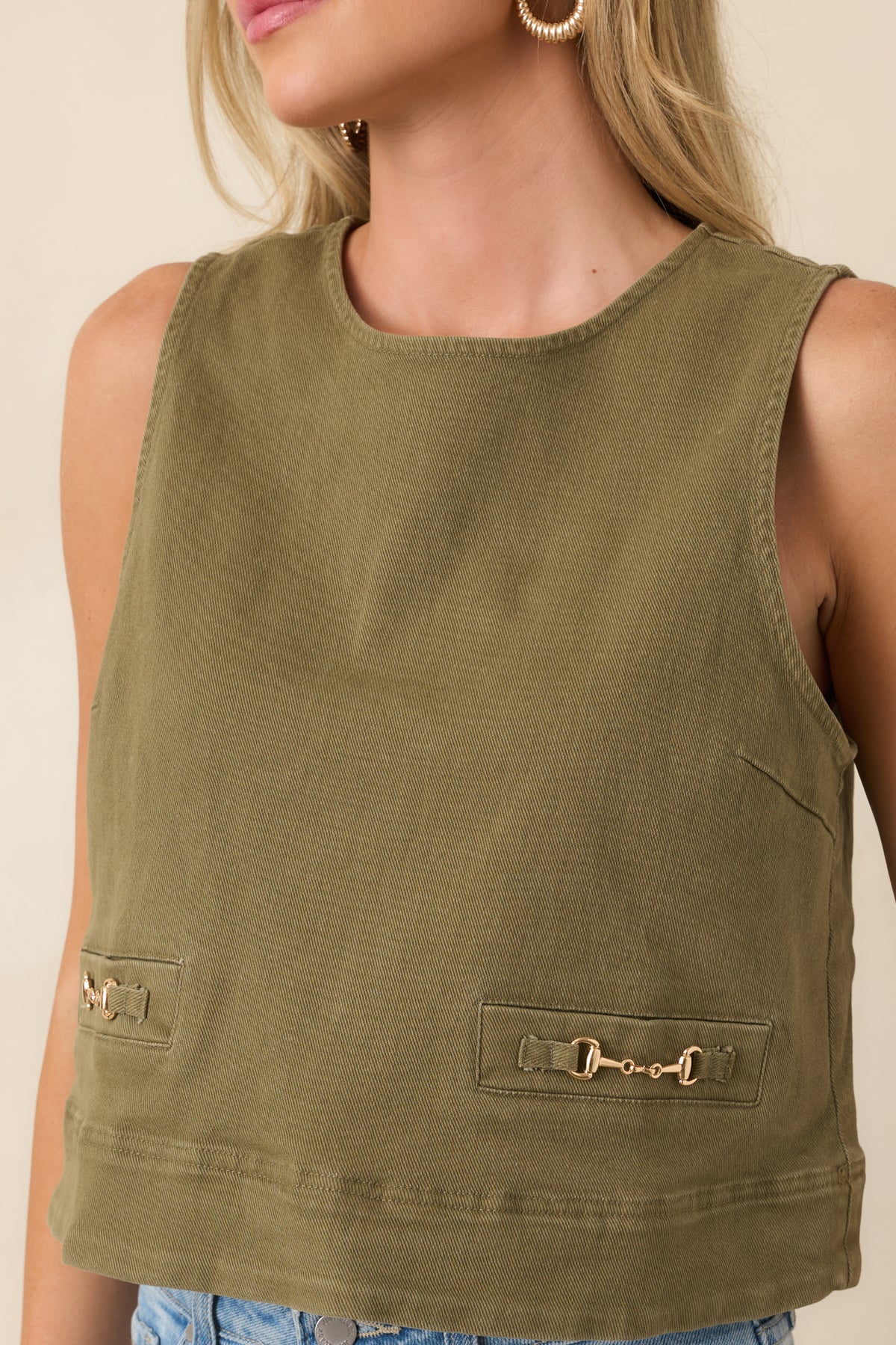 Close-up view of the gold-tone horsebit hardware, welt details, and denim texture.
