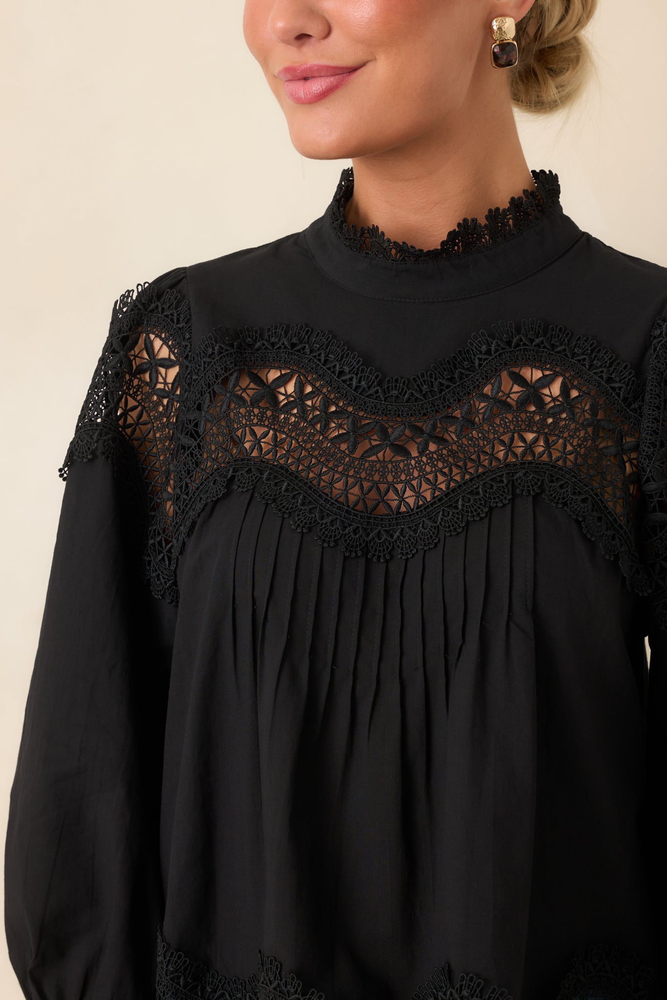 Close-up view of the lace neckline, scalloped openwork yoke, and pintuck details on the blouse.