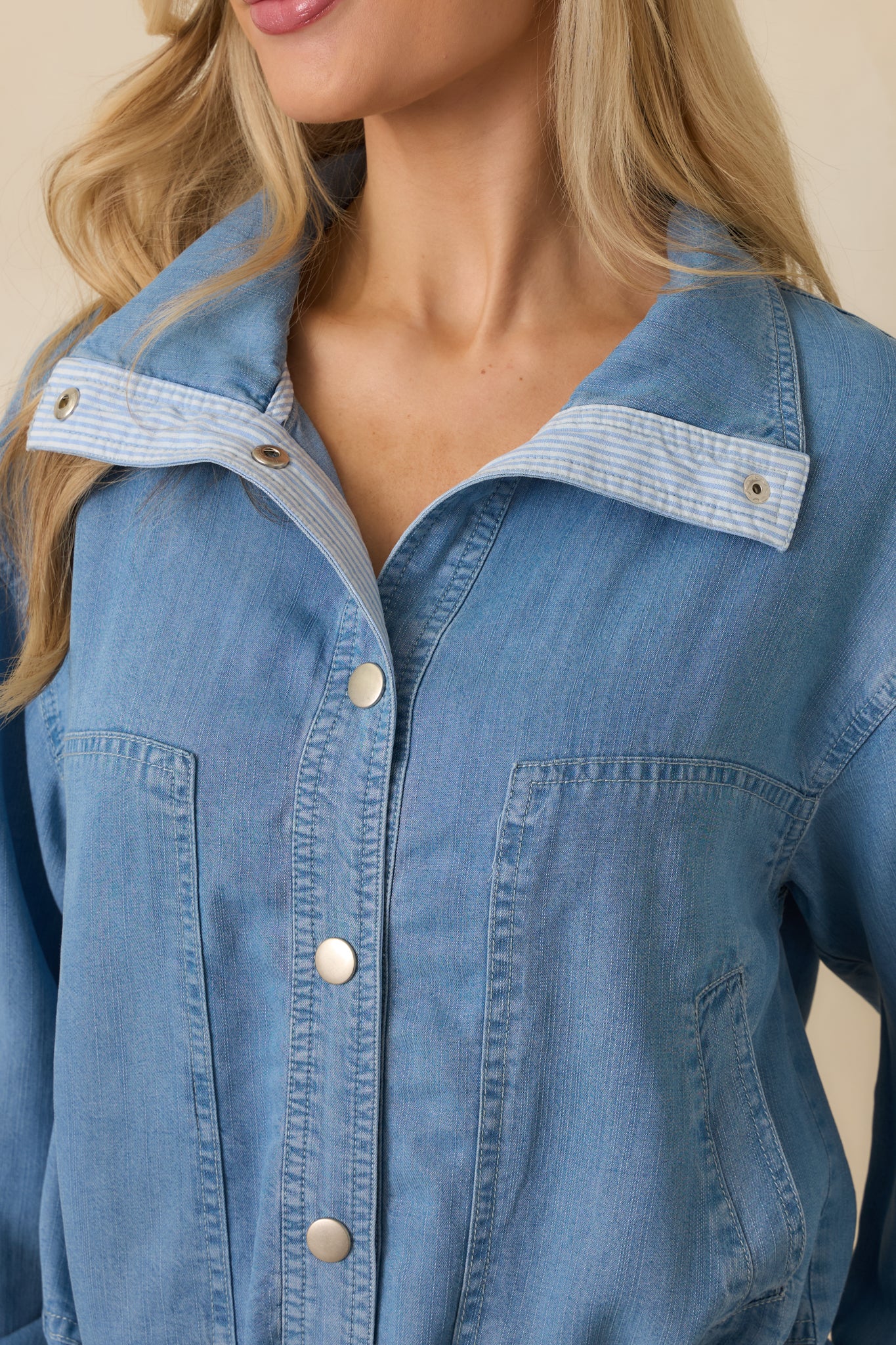 Close-up of silver-tone snaps, drawstring waist ties, and soft lightweight denim texture.