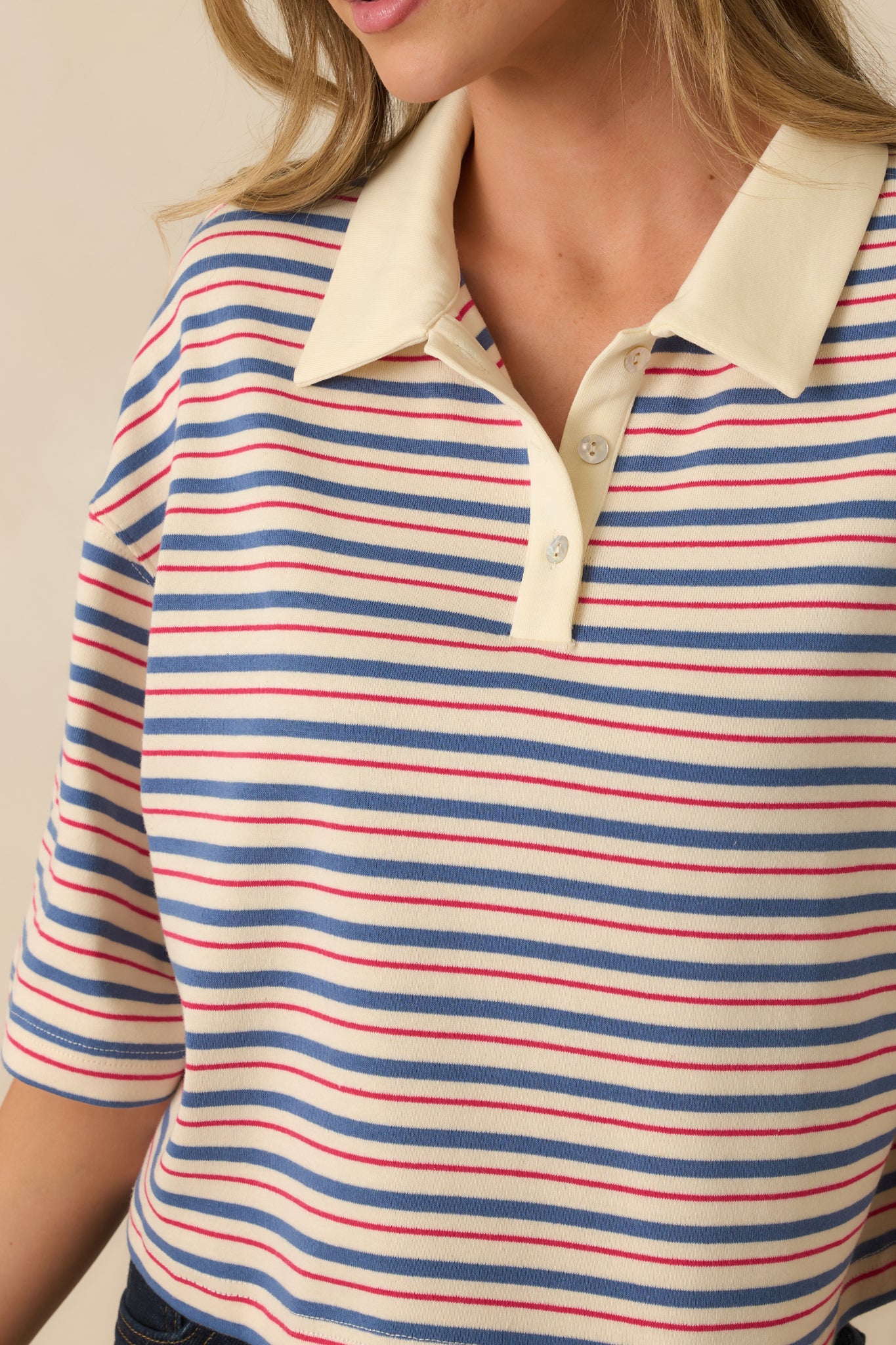 Close-up of blue multi-stripe fabric, solid contrast collar, and partial button placket.