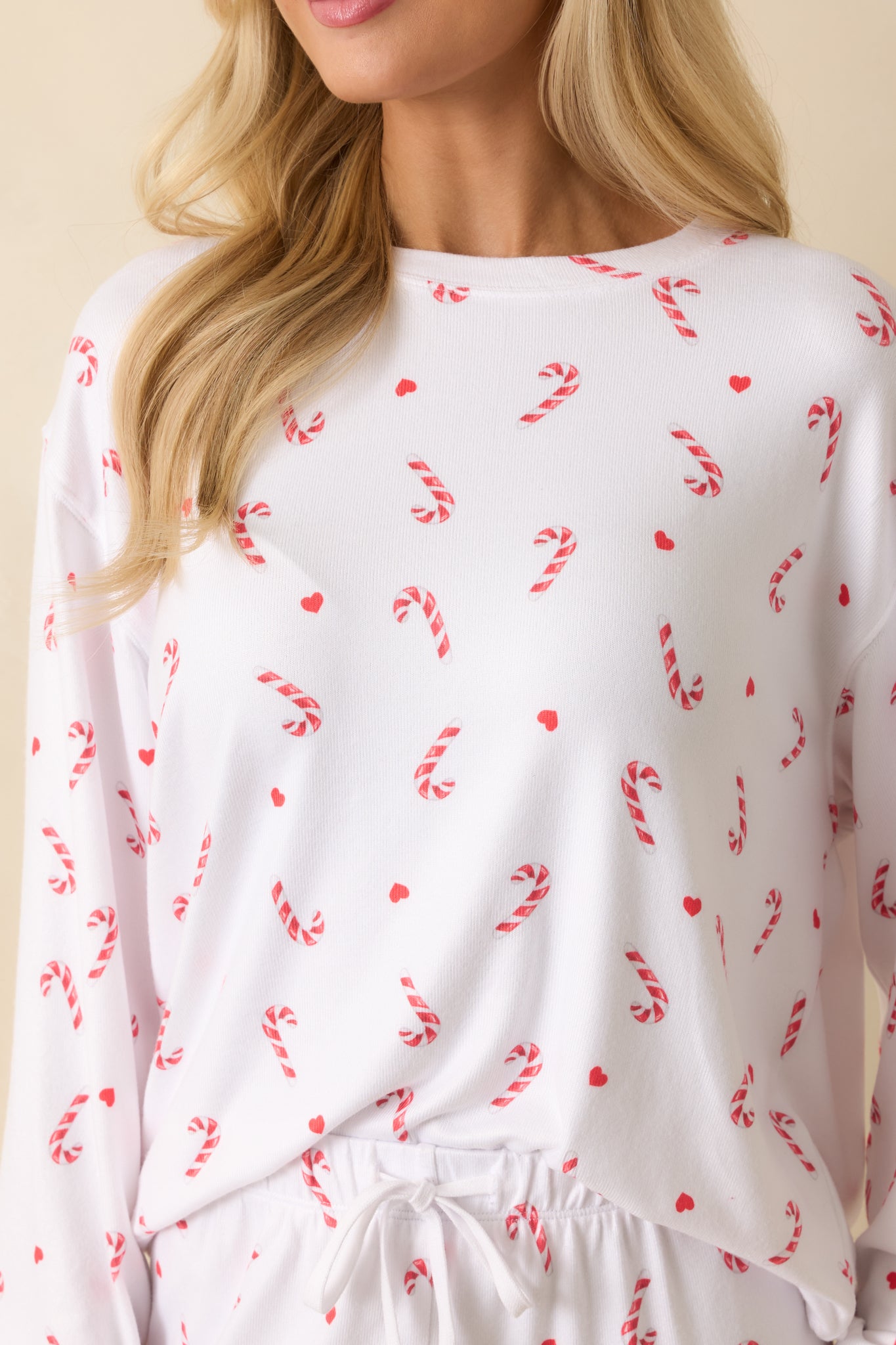 Close-up of the silky jersey fabric showing the candy-cane print and smooth festive texture.