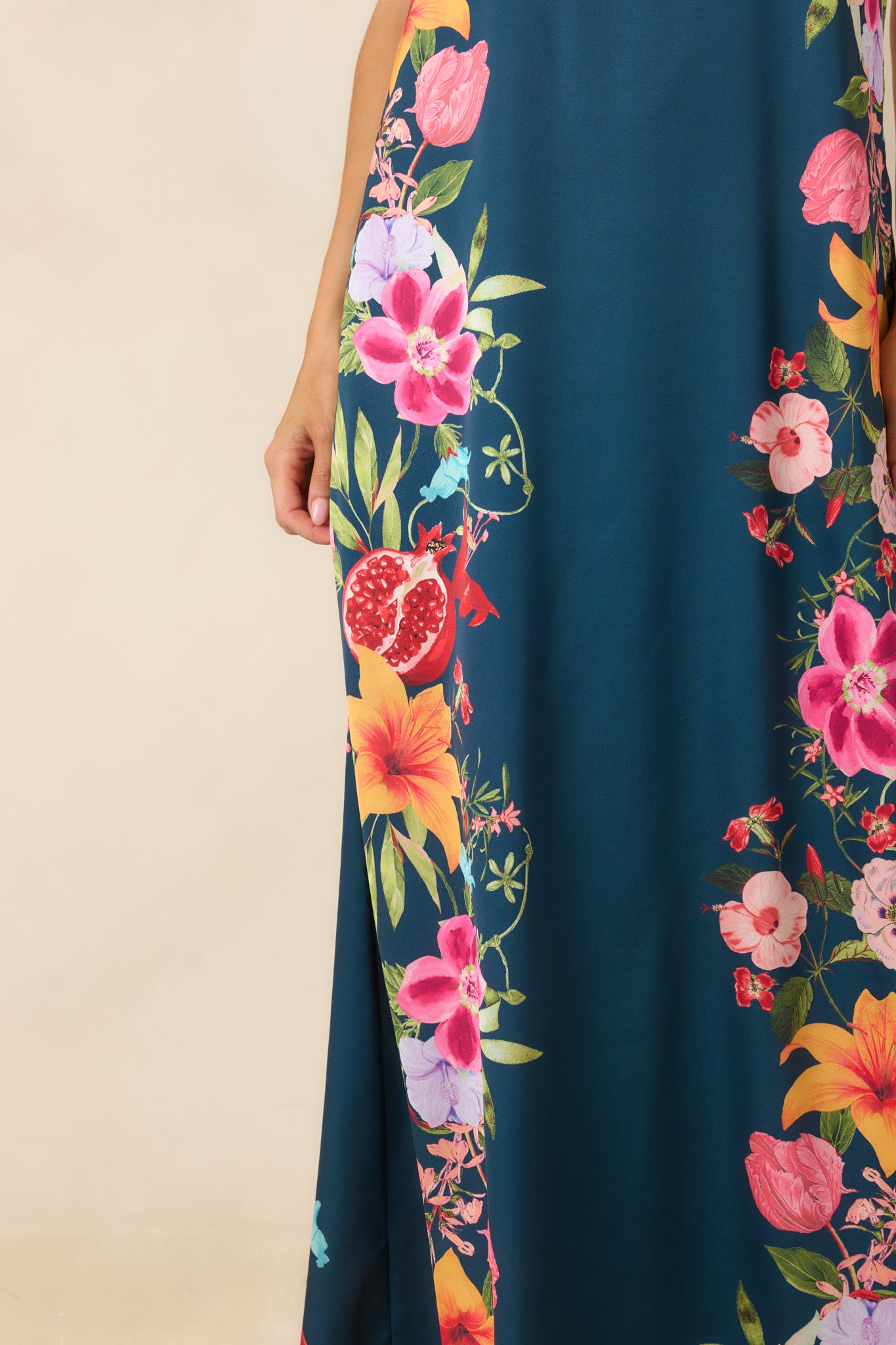 Close-up of the navy floral maxi dress featuring the colorful fruit and flower border print and fabric texture.