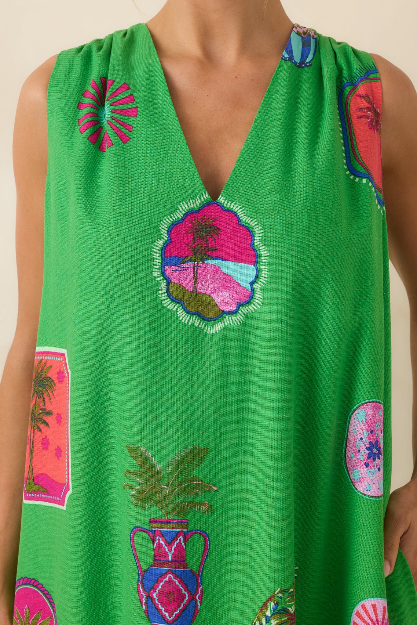 Close-up of green tropical maxi dress highlighting the colorful motifs, V-neckline, and lightweight fabric texture.