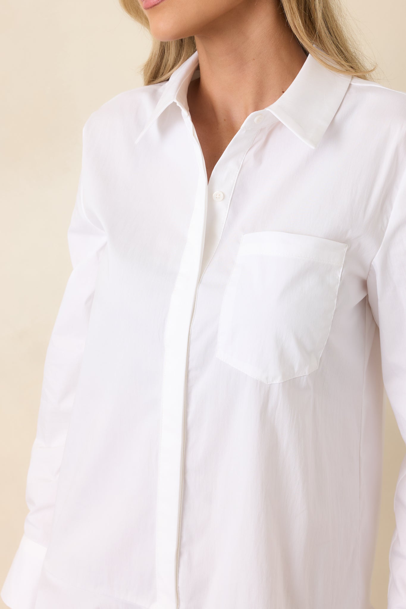 Close-up of the cotton-blend fabric, buttons, and softly flounced hem emphasizing tailored yet playful design.
