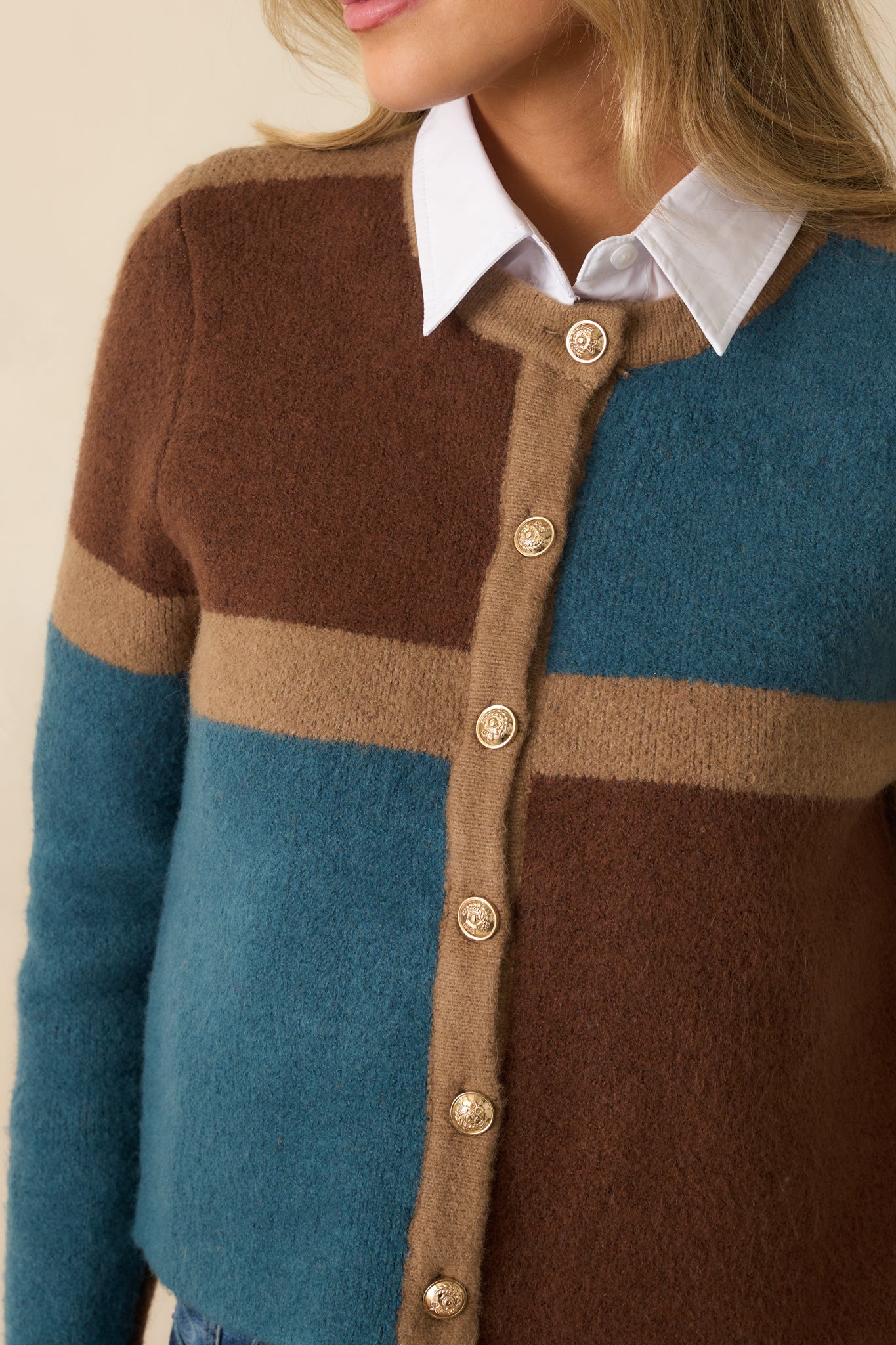 Close-up of the knit fabric and embossed gold-tone buttons with color block detailing.