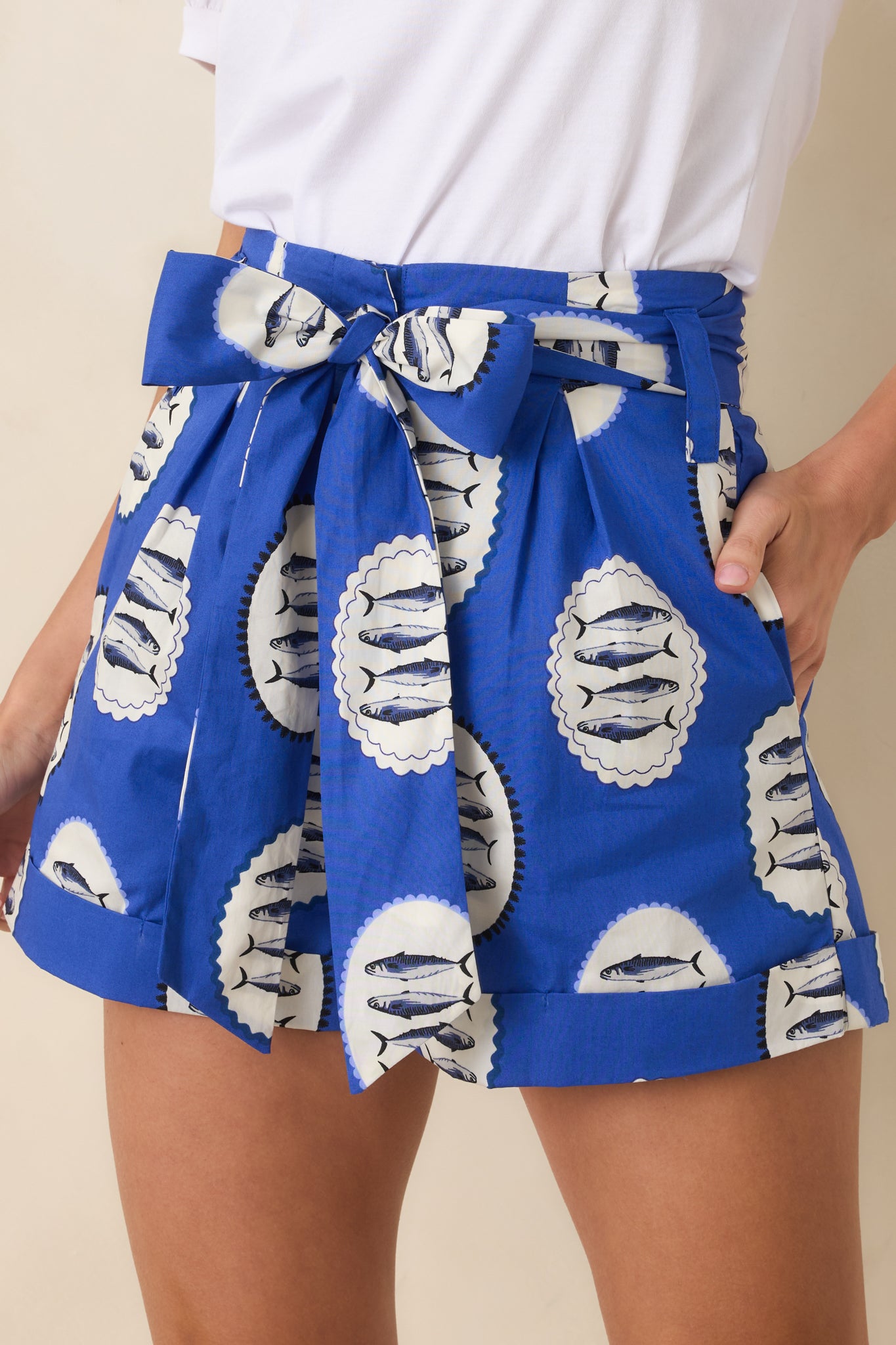 Close-up of the fish print pattern on royal blue cotton and textured woven fabric of the shorts.