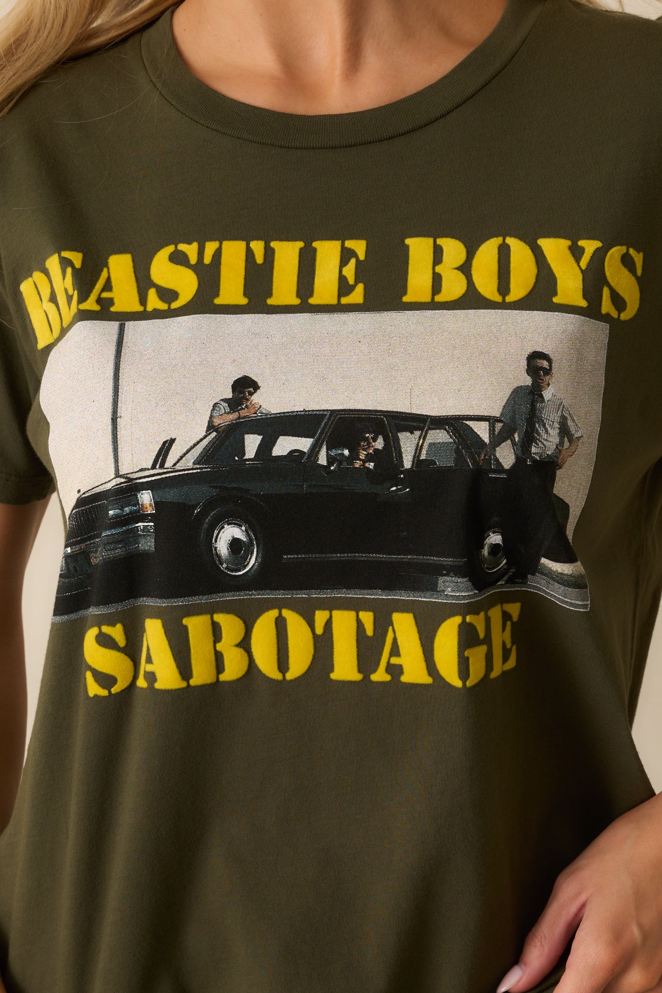 A close-up of the front graphic showing the band image and distressed yellow lettering details.
