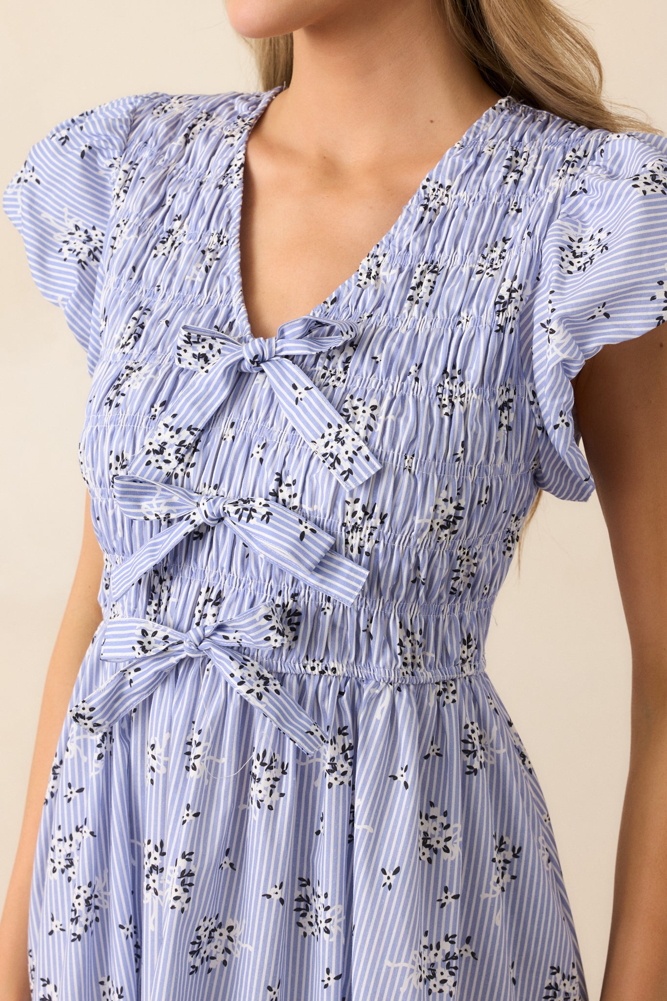 Close-up of the dress’s self-tie bows and smocked panel, highlighting texture and stitching.