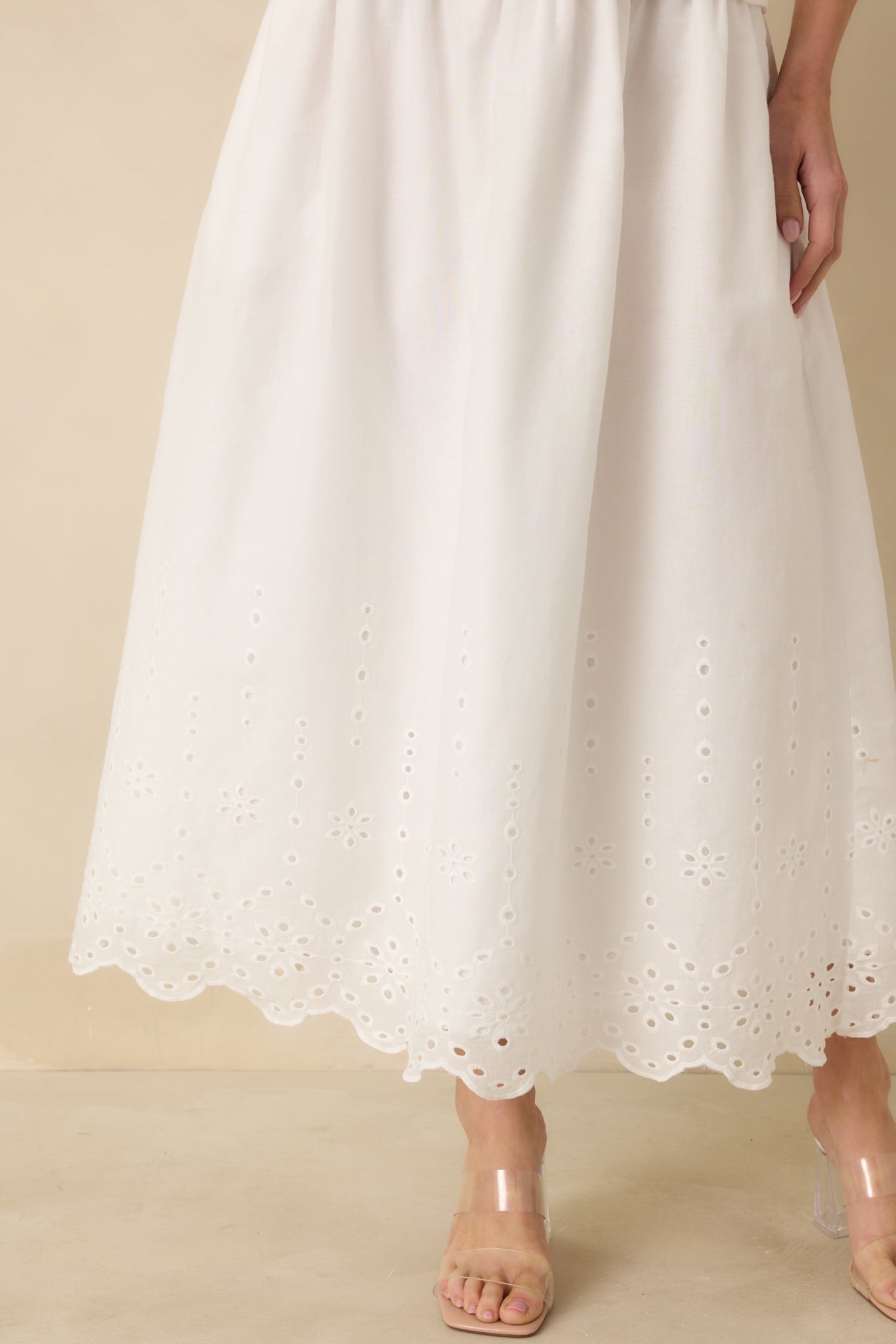 Close-up of the skirt hem highlighting the delicate eyelet lace embroidery and lightweight cotton fabric texture.