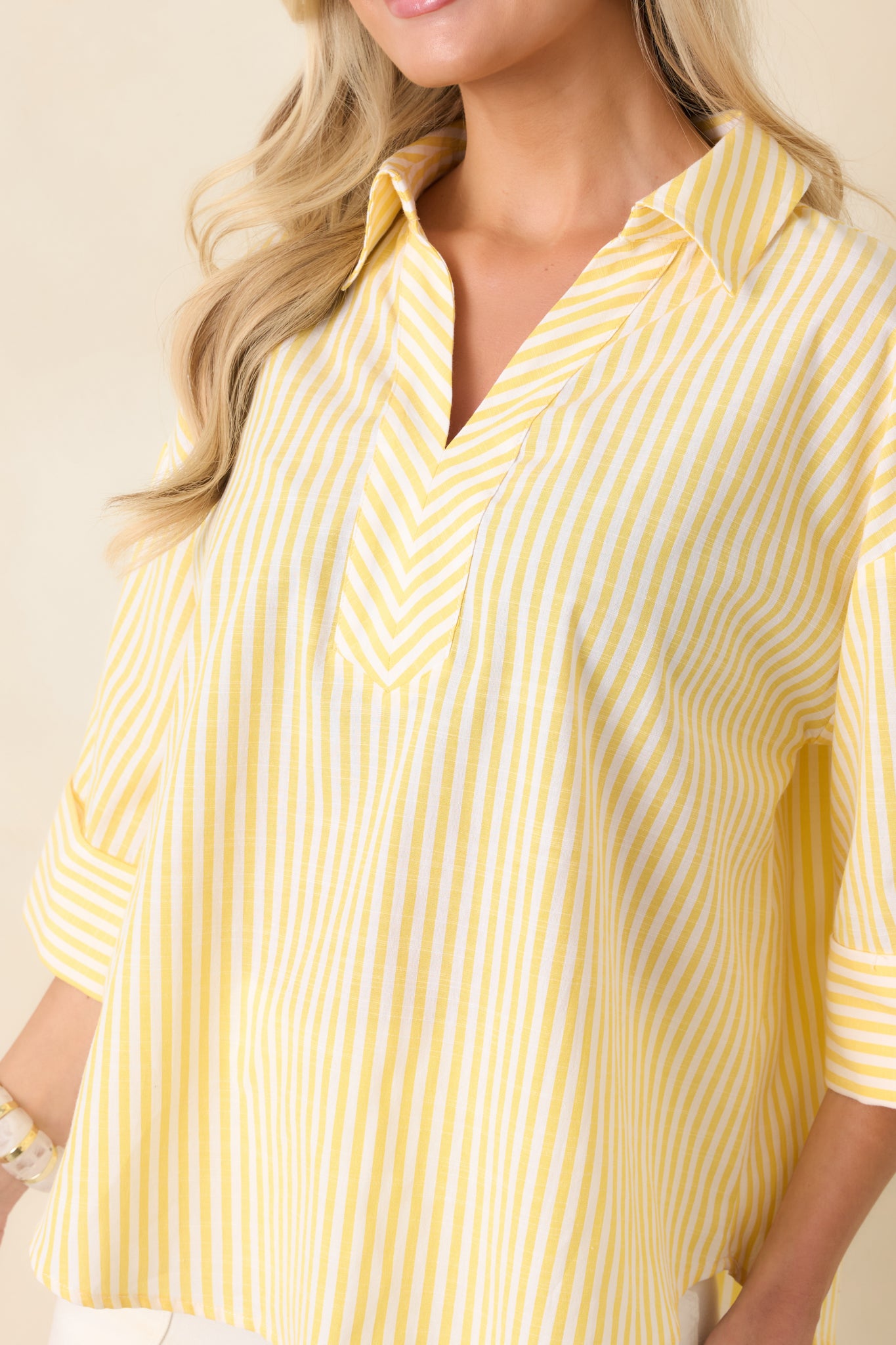 Close-up of the yellow and white vertical stripe fabric showing fine stitching and cuff detail.