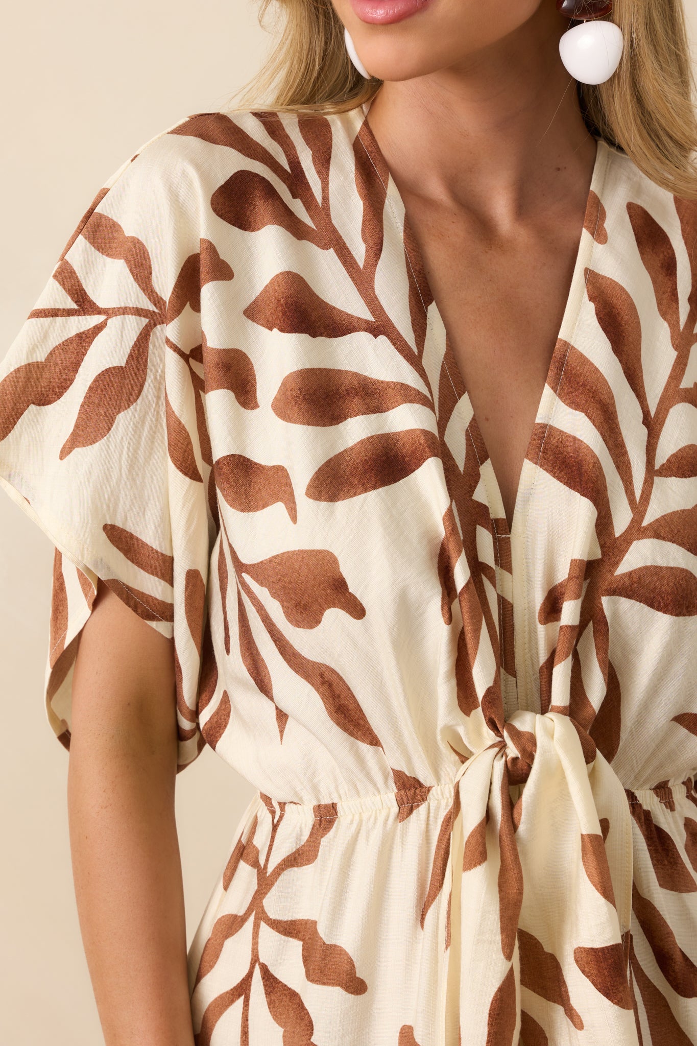 Close-up of the fabric at the waist showing the elastic gathering, light brown print, and texture of the self-tie knot.