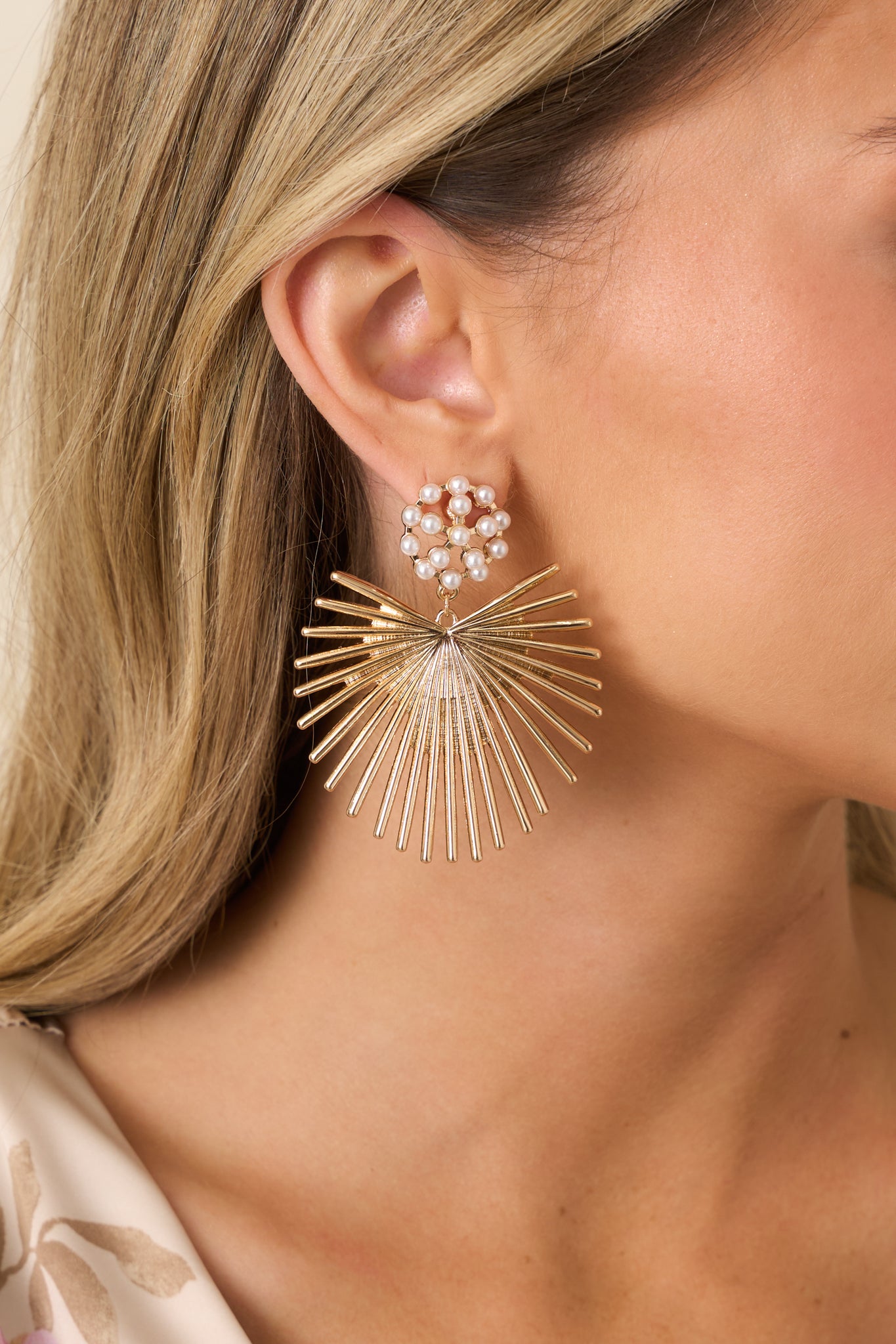 Close-up of the clustered faux pearls, gold stud tops, and open sunburst drop detailing.