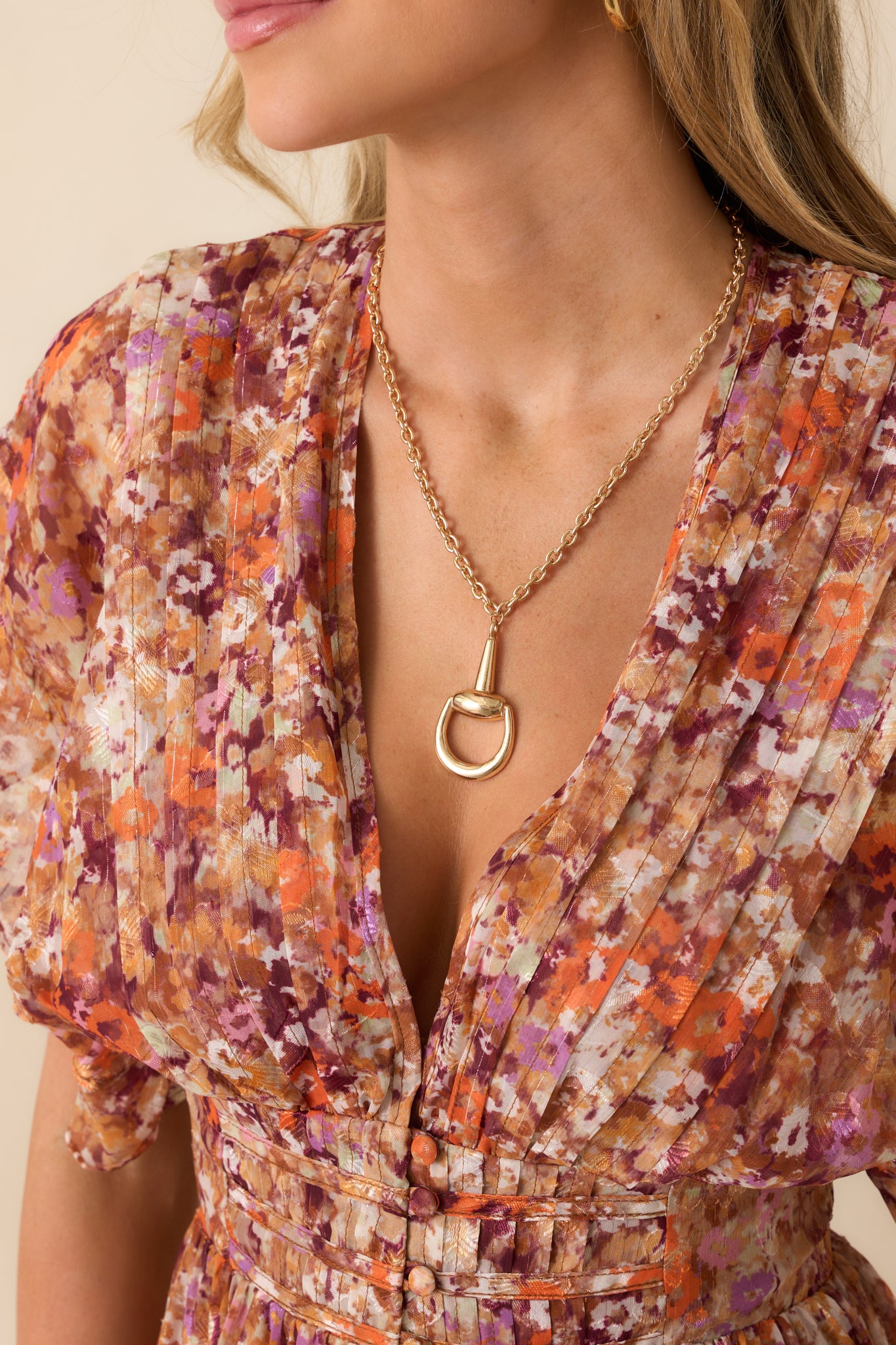 Close-up of the pin tuck pleats and gold tinsel detailing on the terracotta floral fabric.