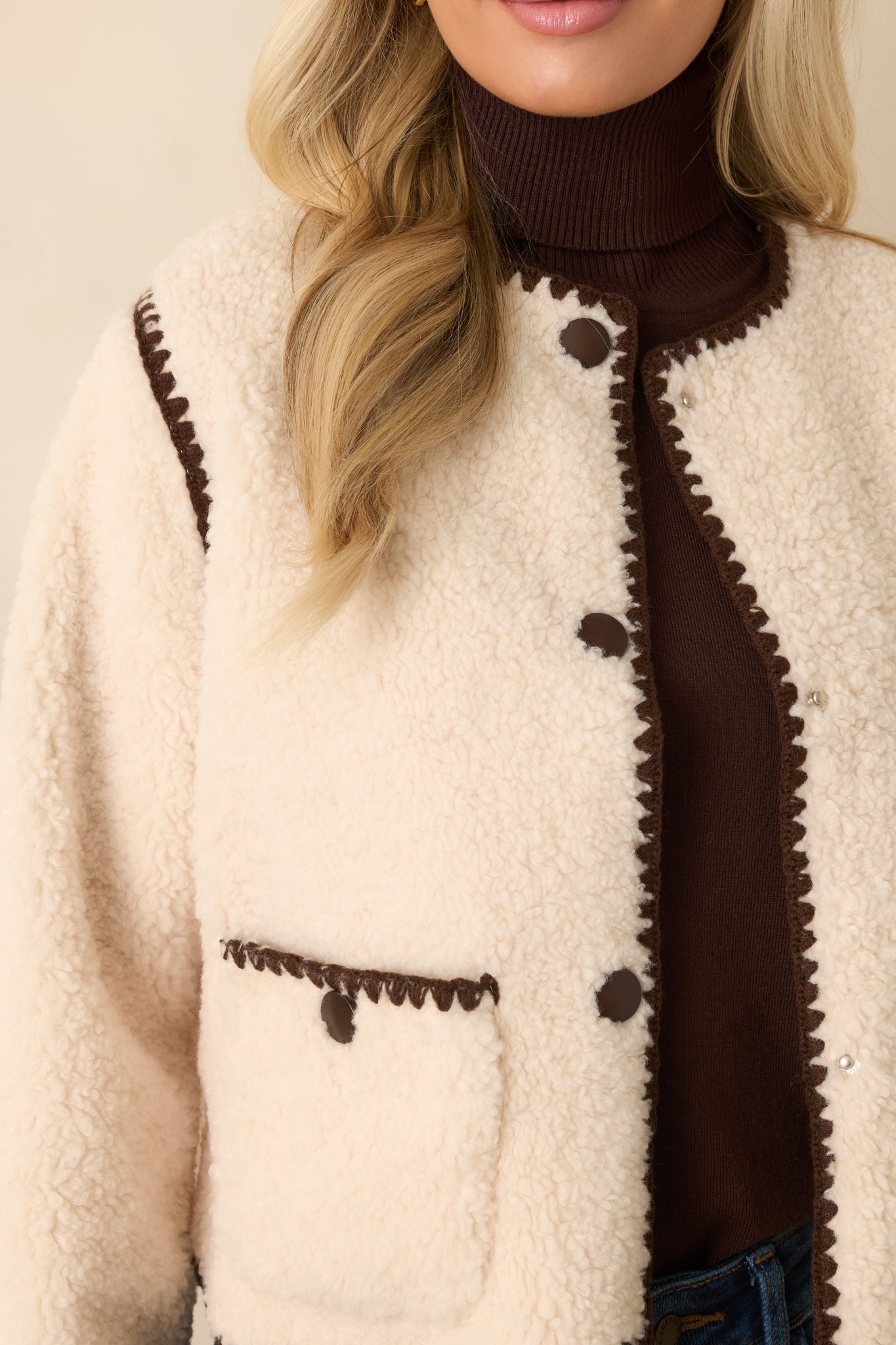 Close-up showing the tactile sherpa finish, neat stitching, and refined trim detail.