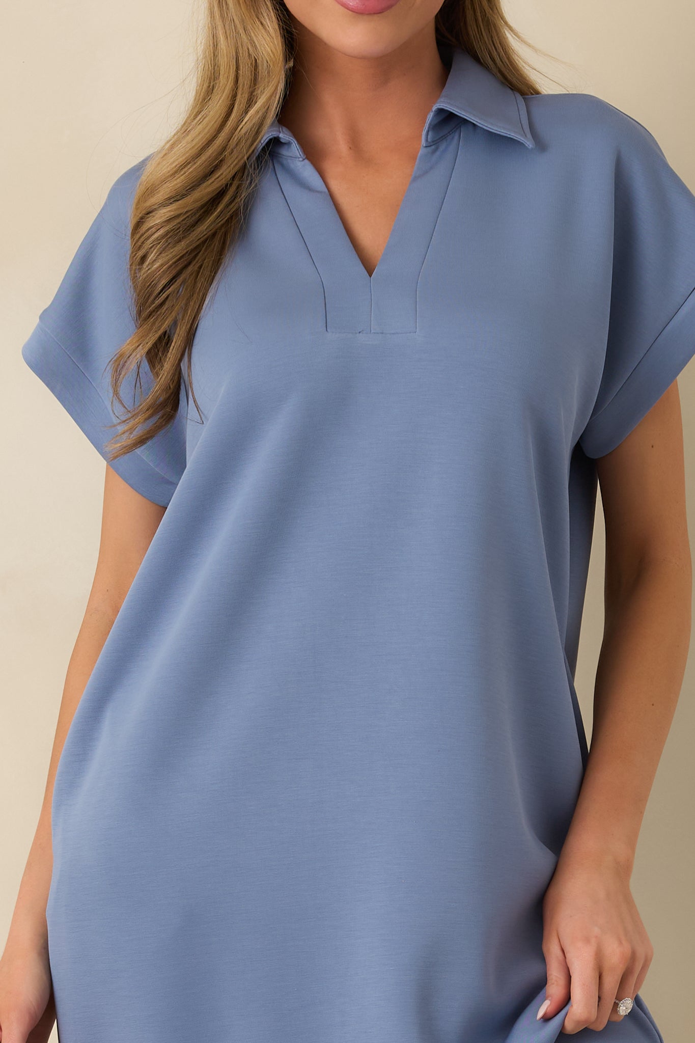 Close-up of the blue midi dress showing the collared notch V-neckline, short sleeves, and pocket detail.