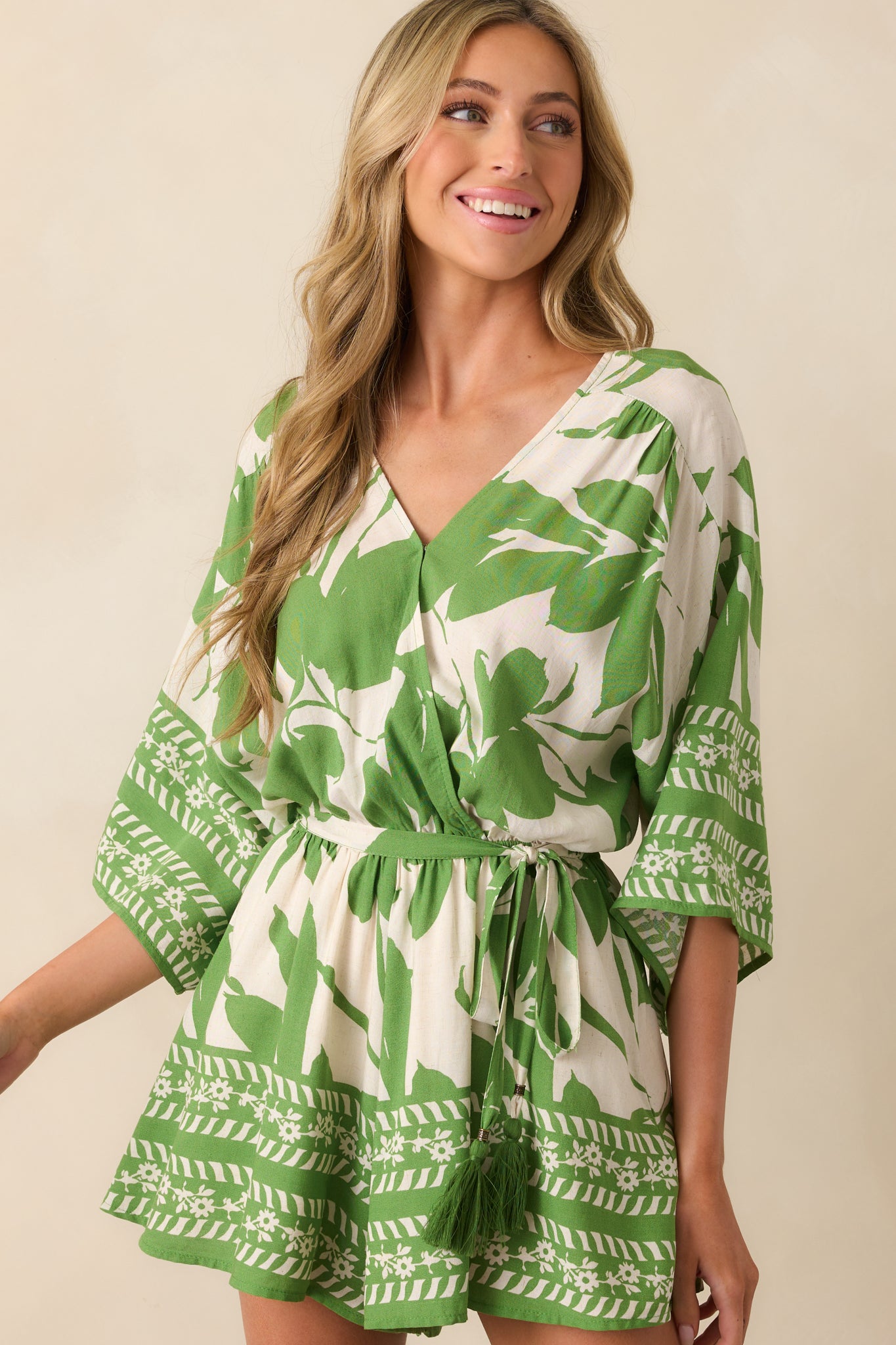 Upper-body close-up showing the deep v-neckline with hidden snap and the mixed floral and stripe print on the sleeve hem.