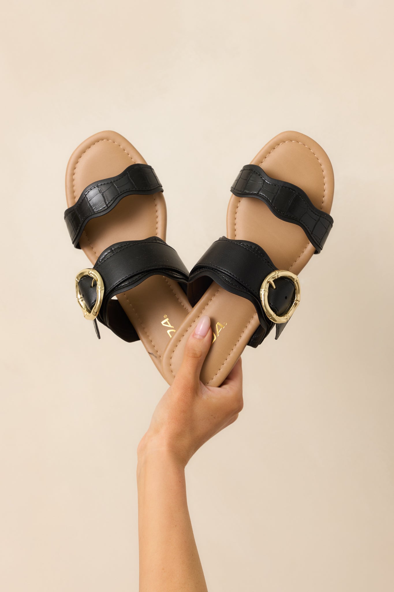 A close-up view focusing on the slip-on design and the intricate scalloped details on the straps.