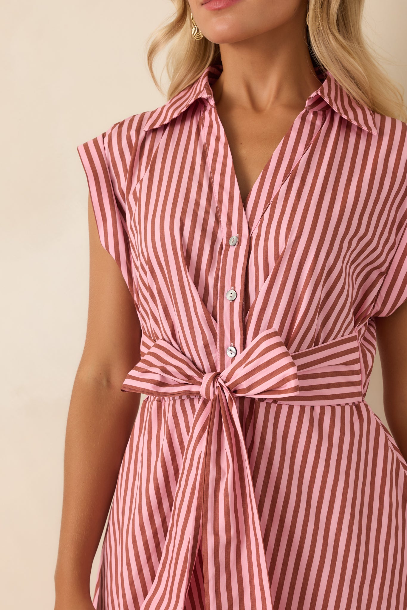 Close-up of the striped cotton dress highlighting the collared neckline, button-front placket, fabric texture, and waist tie detail.