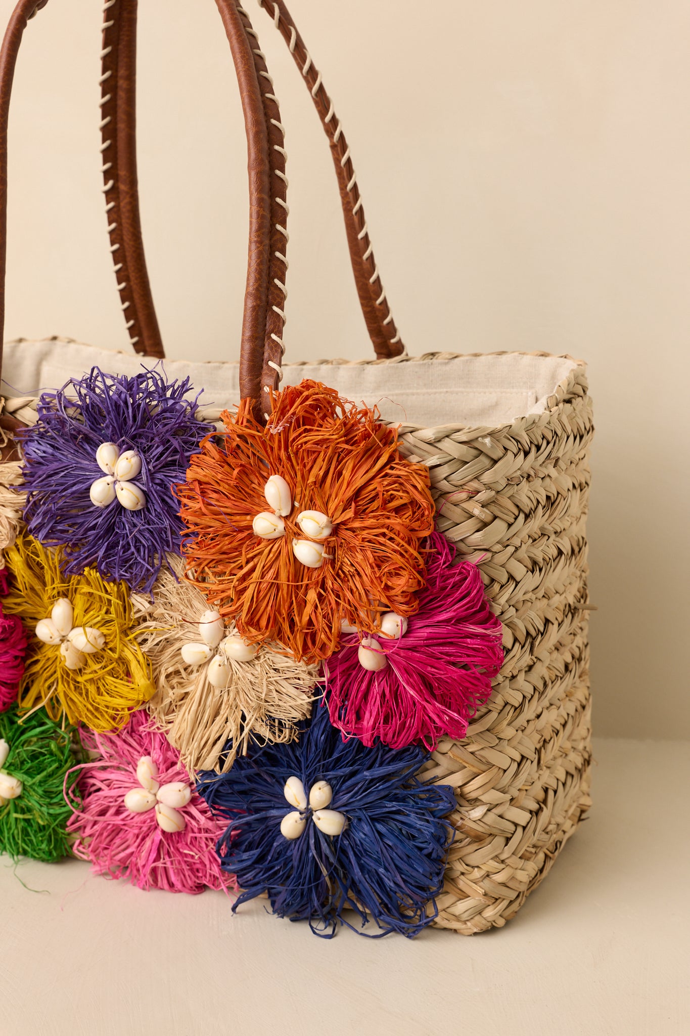 Close-up of the whipstitch detailing, leather-wrapped handles, and textured handbag construction.