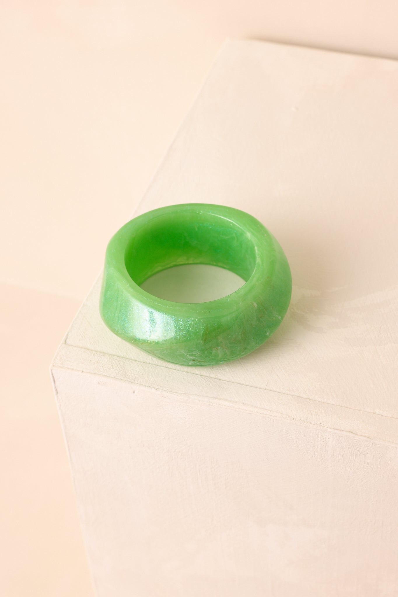 A close-up detail of the twisted textured design with a marbled pattern and subtle glitter flecks in the glossy finish.
